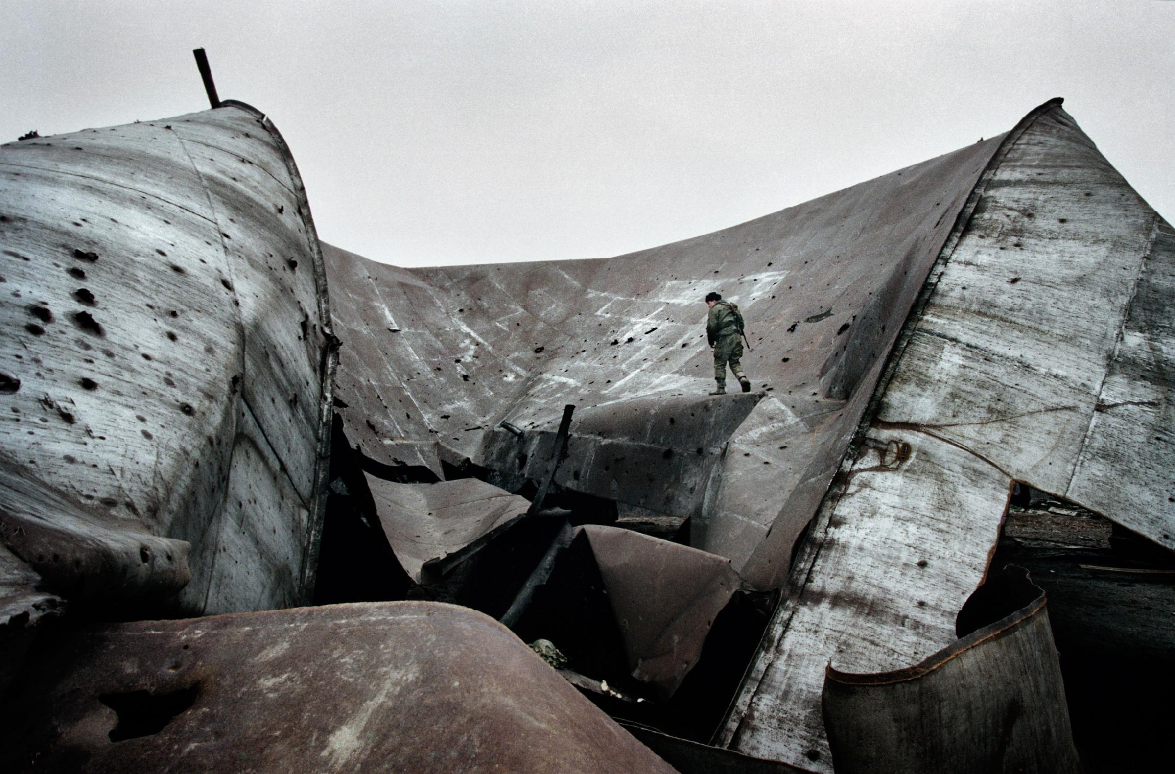 A russian soldier at an oil refinery storage facility that was destroyed in the first Chechen war in Tsentoroi, Chechnya, Dec. 1999.Yuri kozyrev—NOOR