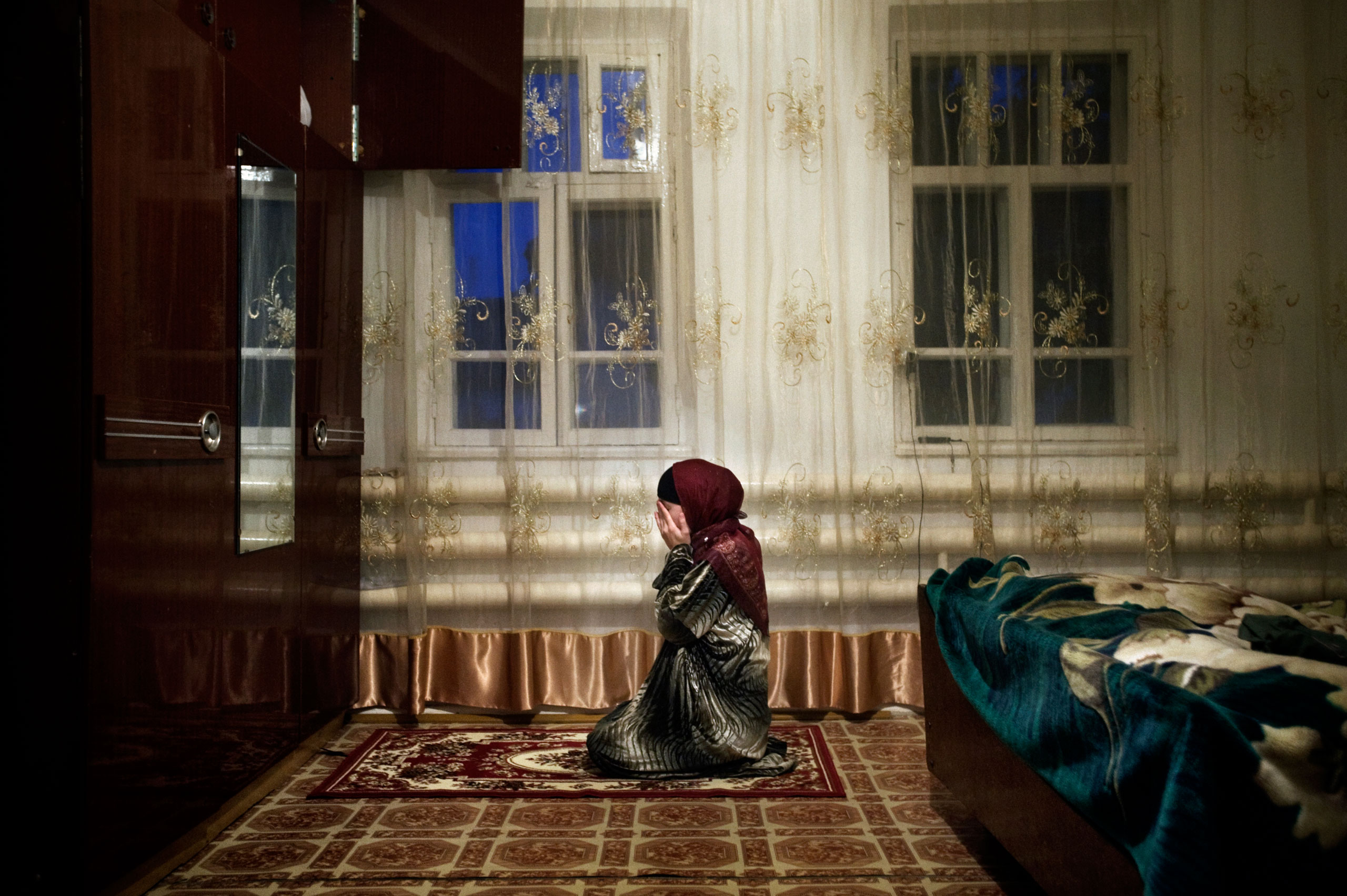 Nurjan prays in her house in Shali, Chechnya. Her brother Yusuf was killed by Chechen military and another brother, Abdul Yazid, was abducted, October 2009.