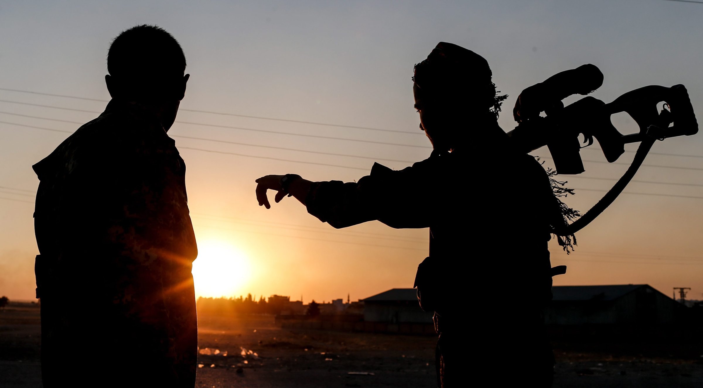 Members of Kurdish People Defense Units (YPG) guard during a sunset near Tel Abyad border gate in northern Syria on June 23, 2015.
