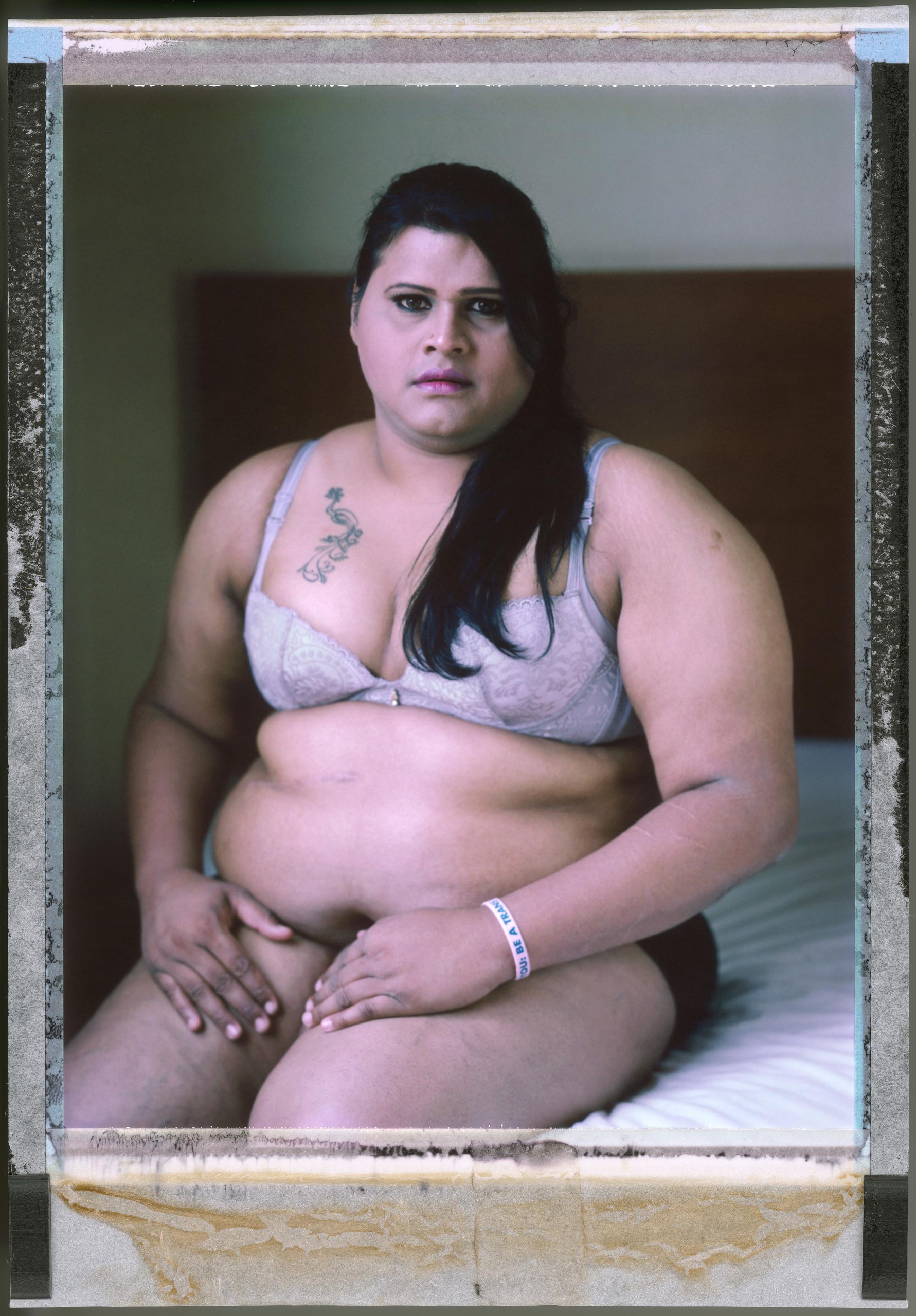 A posed portrait of 33 Year old Abinaya Jayaraman, a transgender woman. Until the age of 19 she always considered herself a normal boy. It wasn’t until her late teens when other boys started to isolate her that she started to question herself. She googled “a man with female character” and started to learn about the transgender community. She went to see a doctor who told her she had a female’s soul trapped in a male’s body. At first she strongly rejected the idea. She wanted to tell her mum but she is from a very strict family and didn’t think it was possible. “I was so scared to tell her, and I started to cut my arm due to depression. I used to hate myself, and I used to hate God “Why did you create me this way?” It took me more than three years to accept who I am. Then I started to dress up in the house. And I would see my mum’s Saree and think “when will it be my turn to wear that?”. In June 2008 she told her mum “Ma, I’m not a boy, I’m a girl, please understand” Abinaya’s mother slapped her in the face and walked away. One evening in 2009, Abinaya came home after work “all my relatives were there. I asked “what’s going on?” – my mother told me – “we’re going to look for a wife for you” I was shocked. I said “what? Please understand I cannot carry her leg like this and bang her!”” Her mother replied “Don’t worry, once you have a child, everything will be okay”. Her relatives tried to introduce her to a woman. Abinaya met her wife to be, and told her “Look I can’t marry you” then Abinaya explained everything. The pressure continued though until Abinaya couldn’t take it any longer and in April 2009 she took a cocktail of sleeping pills and pain killers in an attempt to end her life. She ended up in hospital for 3 months. Her mother didn’t visit her once. Abinaya’s family continued to refuse to accept her gender identity. She was disowned and thrown out of the house. Abinaya worked in corpor