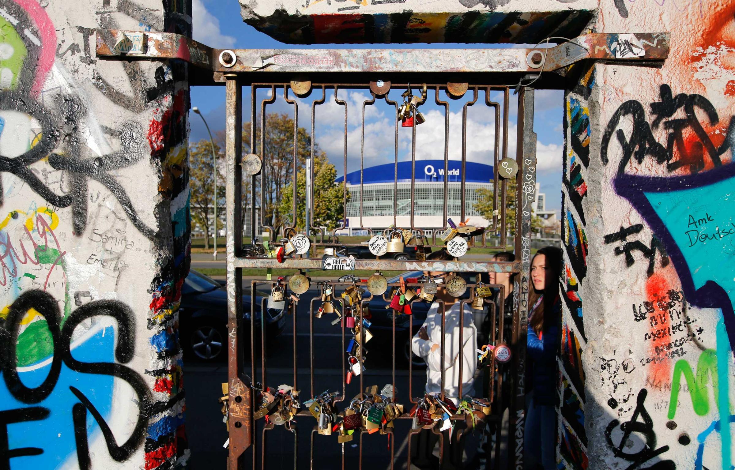 Padlocks symbolising people's romantic relationships are attached at a gate on painted segments of the East Side Gallery in Berlin