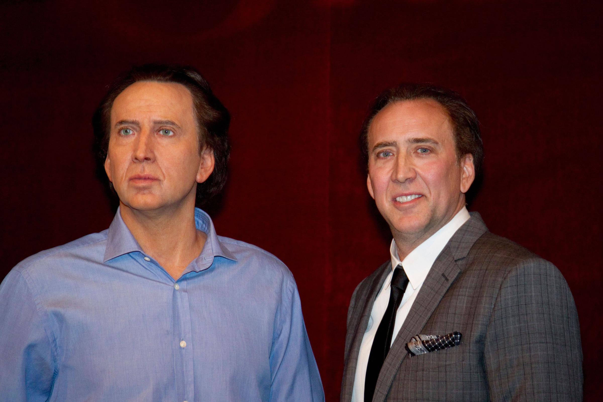 U.S. actor Cage stands next to his figure at the Grevin wax museum during the presentation of his waxwork in Paris