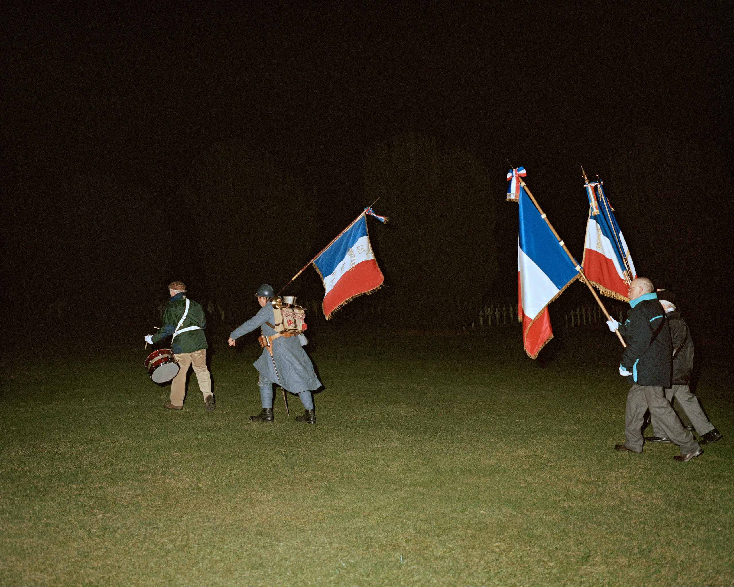 Les Témoins de l'Histoire, 95th Anniversary of the
                              Battle of Verdun, 2011
                              
                              Members of the Les Témoins de l'Histoire à la RATP cross the cemetery to attend a night mass at the Douaumont Ossuary at the annual torch parade.
