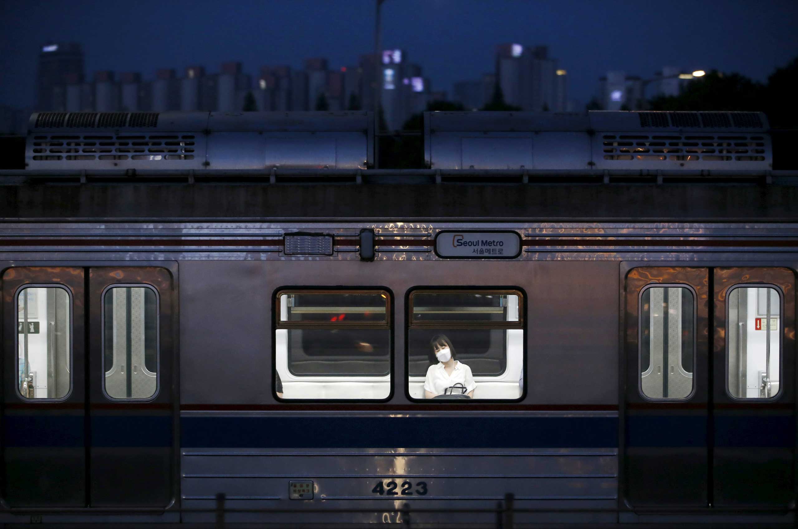 A woman wearing a mask takes a nap as she rides a subway train in Seoul on June 12, 2015.