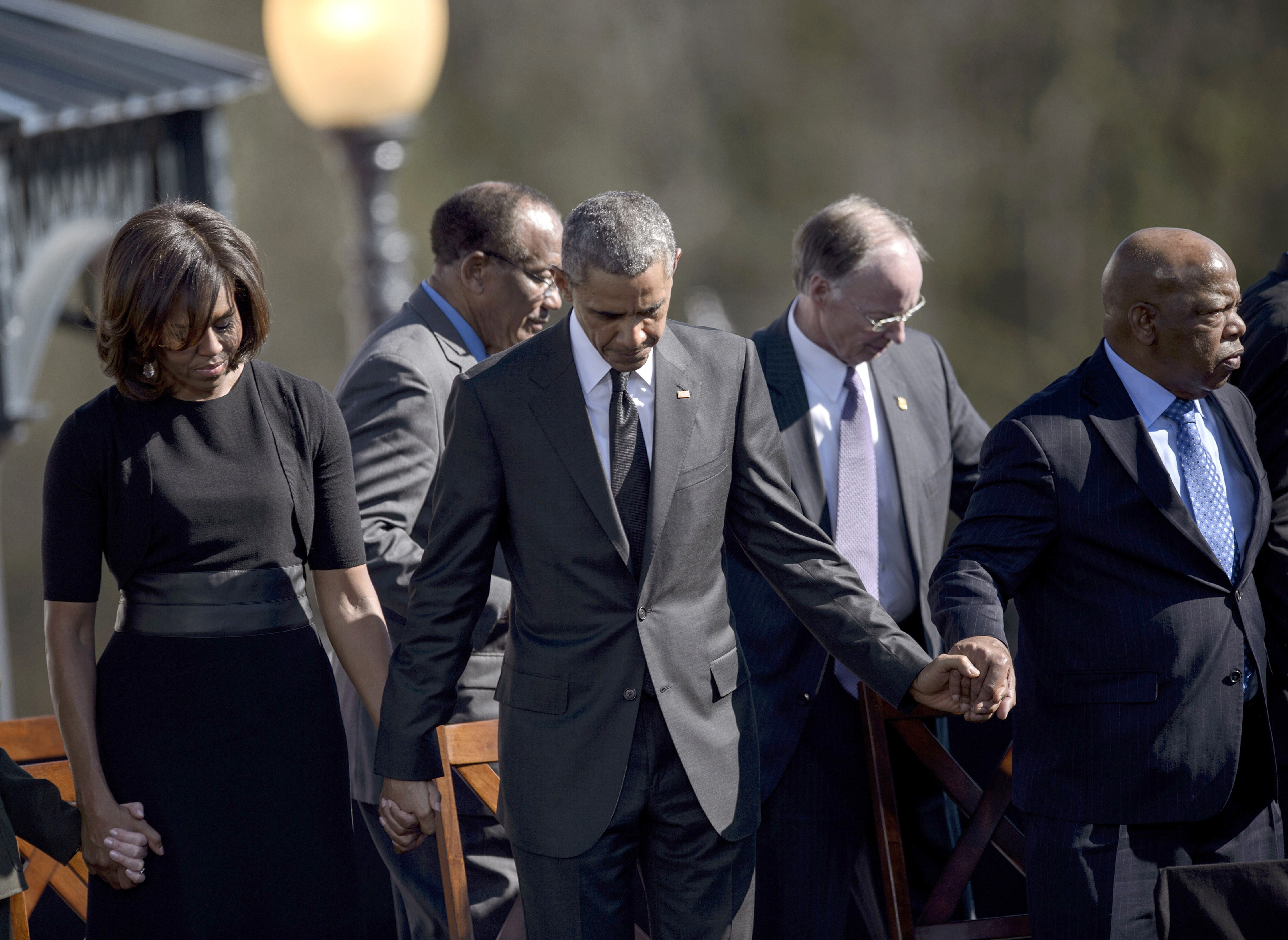 From left: First Lady Michelle Obama, President Barack Obama, Robert J. Bentley and Rep. John Lewis bow their heads for a prayer at the Edmund Pettus Bridge in Selma, Ala. on March 7, 2015.