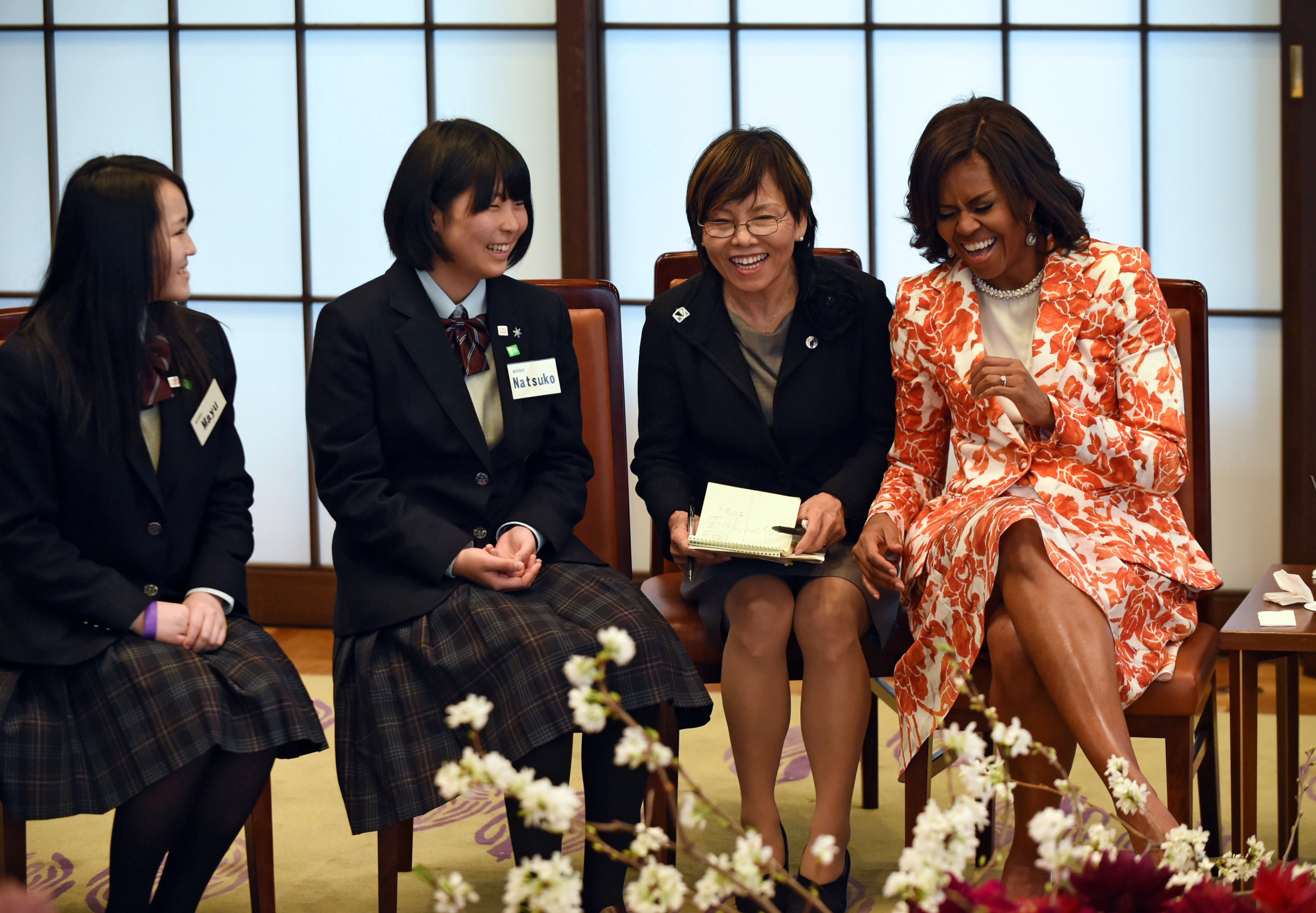 First Lady Michelle Obama shares a laugh with school girls as she attends the Japan-US Joint Girls Education Event at the Iikura Guest House in Tokyo on March 19, 2015.