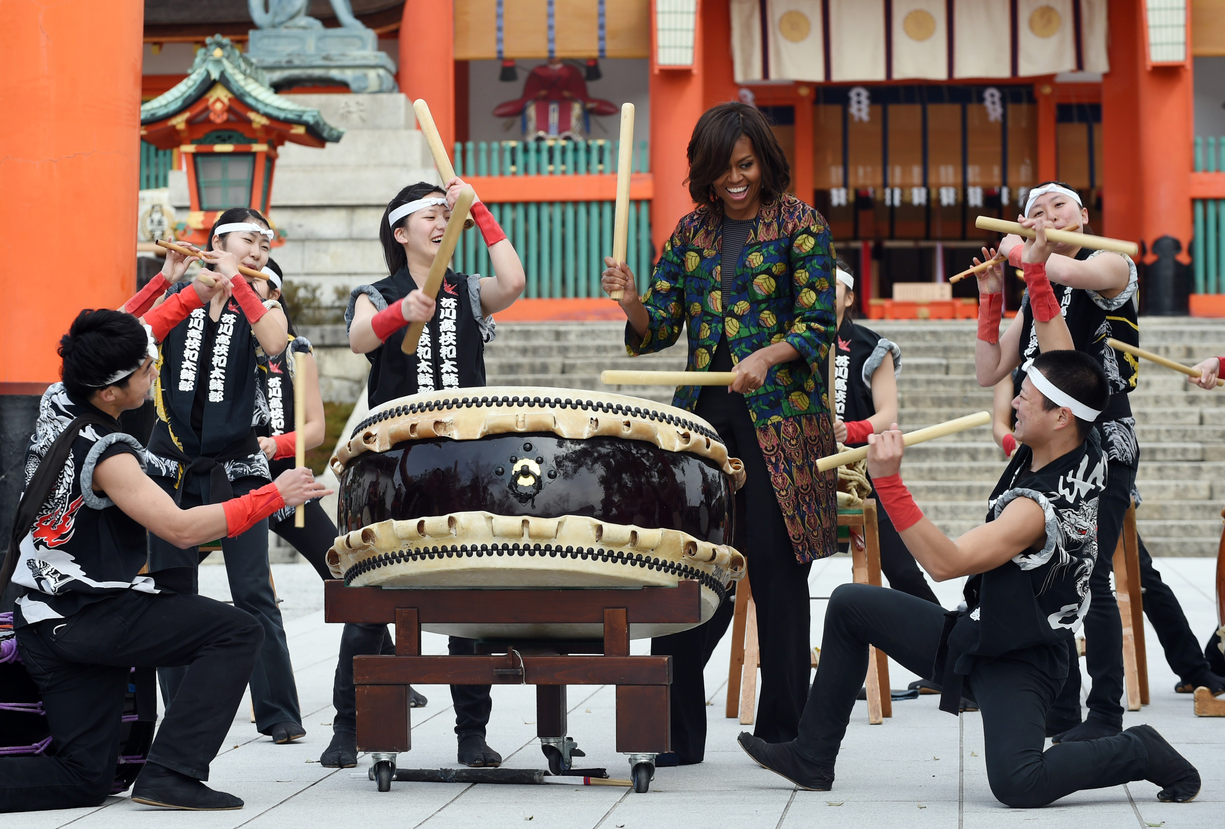 First Lady Michelle Obama plays the Taiko (Japanese traditional drum) with Manaka Hirose and members of the Akutagawa high school Taiko Club while visiting the Fushimi Inari shrine in Kyoto on March 20, 2015.