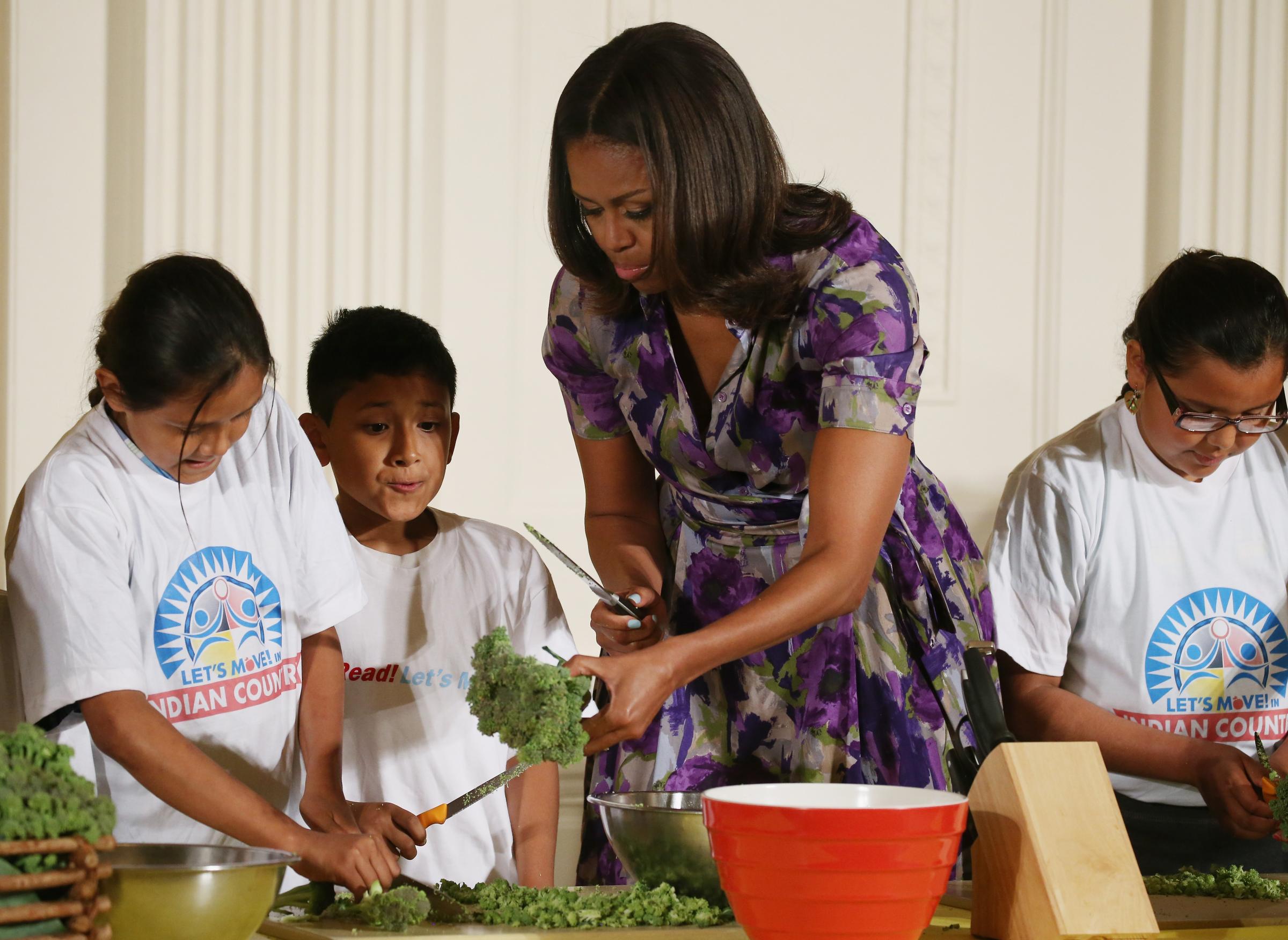 WASHINGTON, DC - JUNE 03: First lady Michelle Obama is joined by local students in preparing vegetables that were recently harvested from the White House garden, in the East Room at the White House June 3, 2015 in Washington, DC. The first lady and local students enjoyed eating the vegetables they planted in the garden on the South Lawn to initiate a national conversation around the health and well-being. (Photo by Mark Wilson/Getty Images)