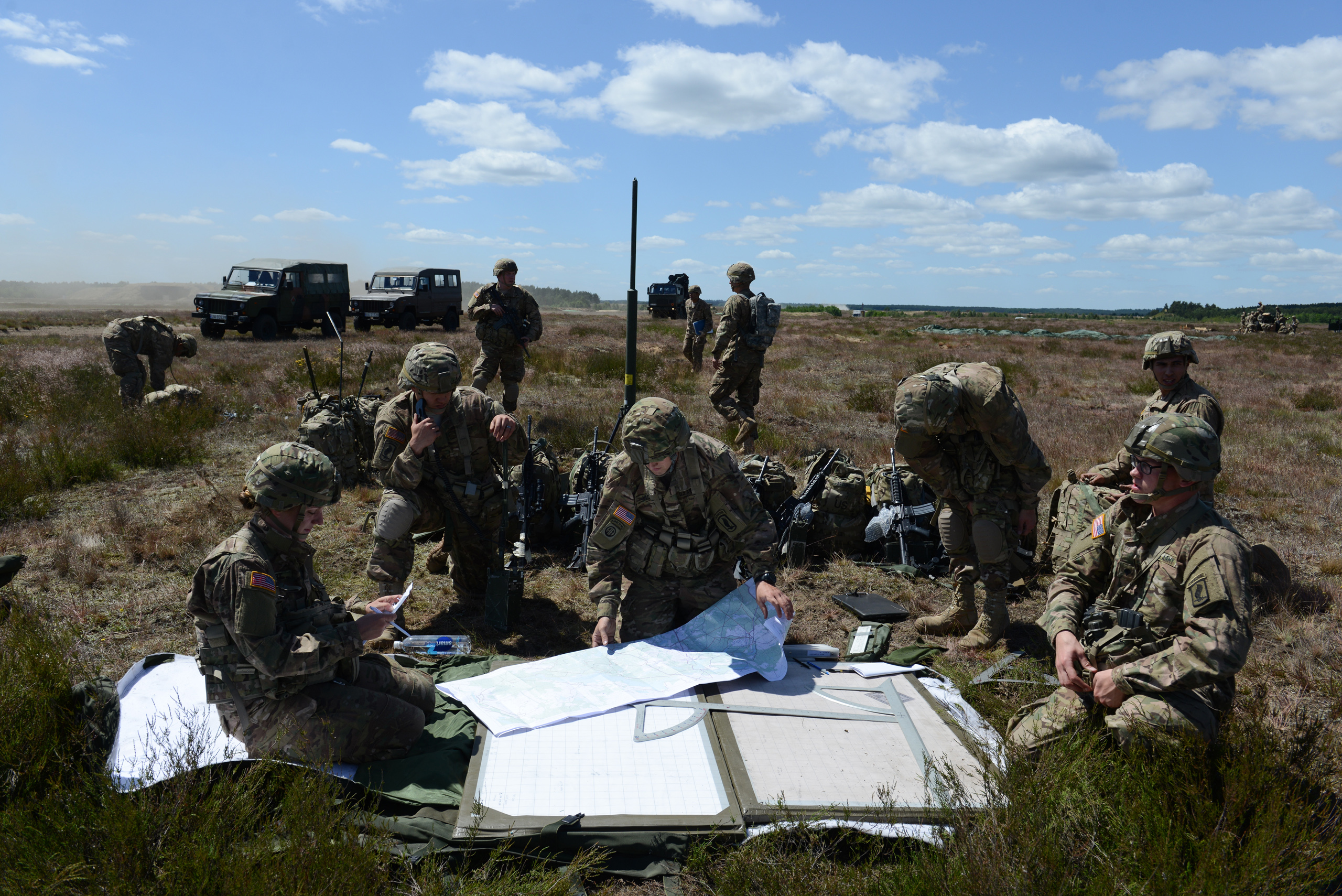 American soldiers with the Fourth of the 319th Airborne Field Artillery Regiment of the 173rd Infantry Brigade Combat Team examine their maps and communications following an airdrop from a C-17 aircraft that took off from Nuremberg, Germany and dropped at the Drawsko Pomorskie Training Area in Poland on June 15, 2015.