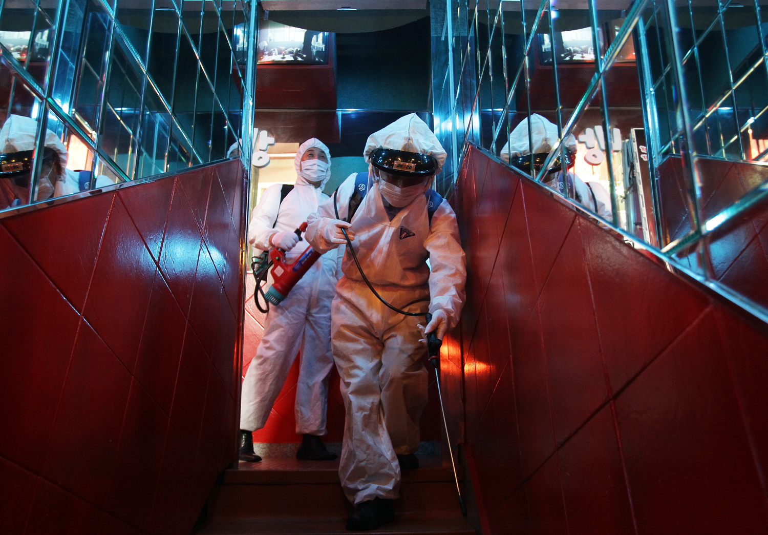 Disinfection workers wearing protective clothing spray anti-septic solution in a karaoke parlor on June 16, 2015 in Seoul, South Korea. (Chung Sung-Jun —Getty Images)