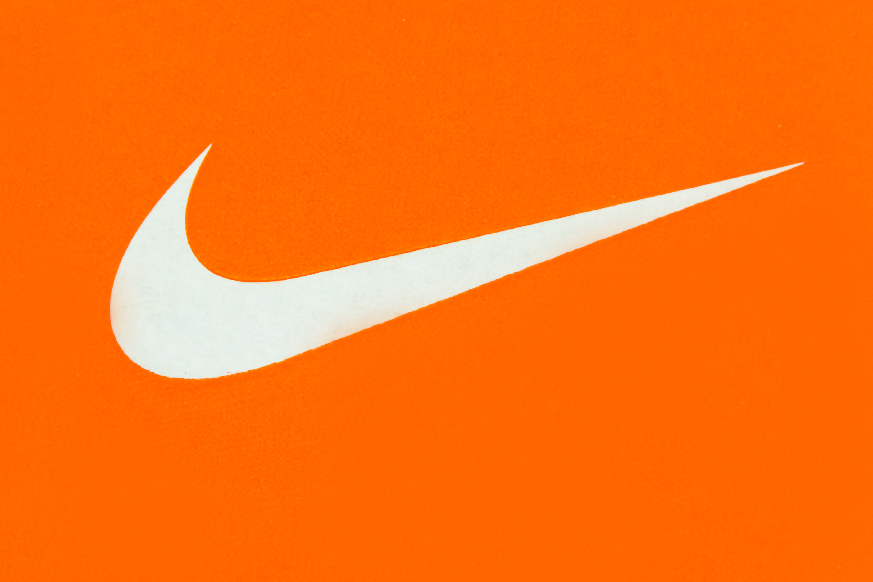 White Nike Logo on Orange Background (Roberto Machado Noa—Getty Images)