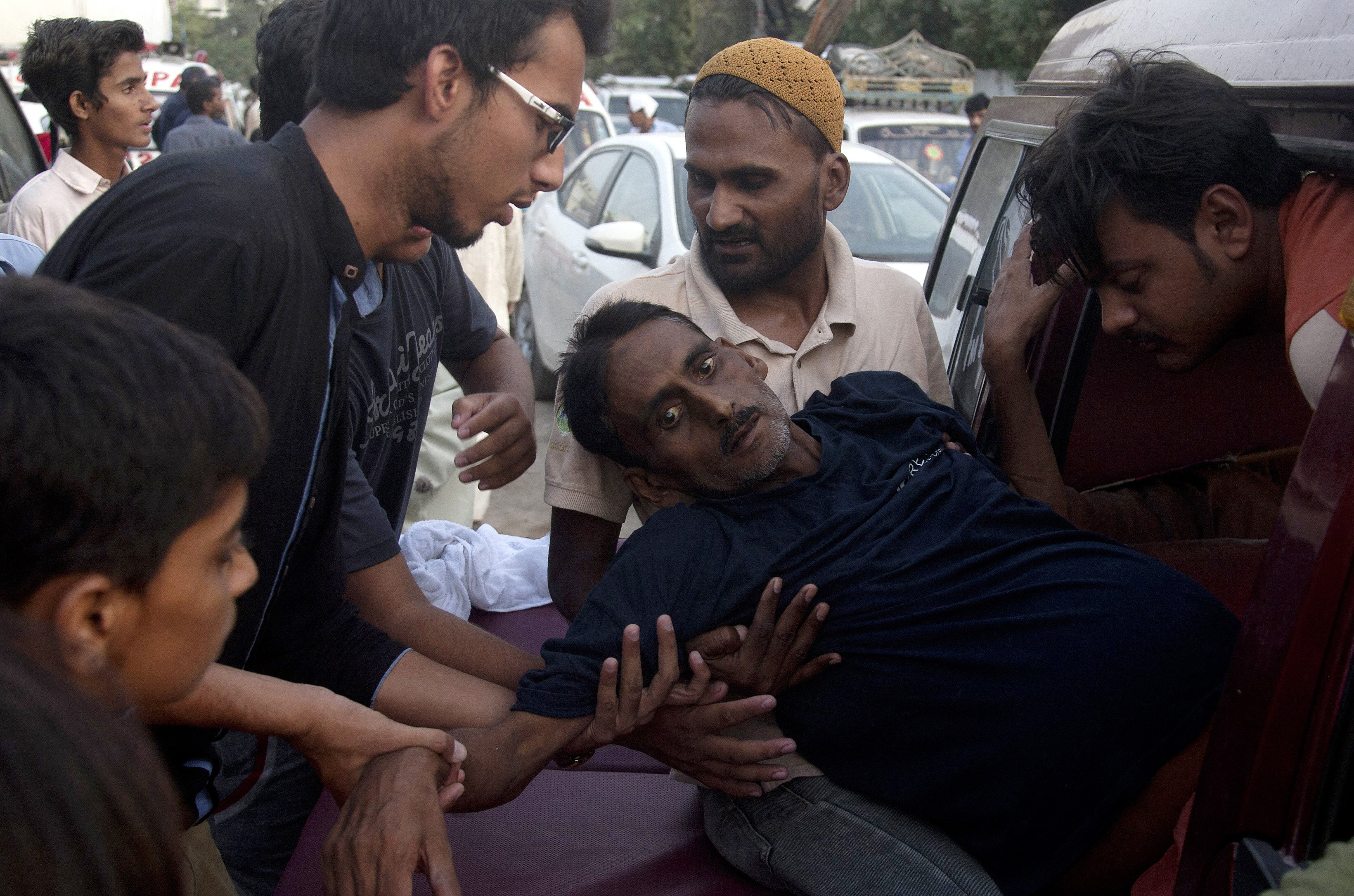 People rush a man to a hospital as he suffers from a heatstroke in Karachi, Pakistan, on June 23, 2015.