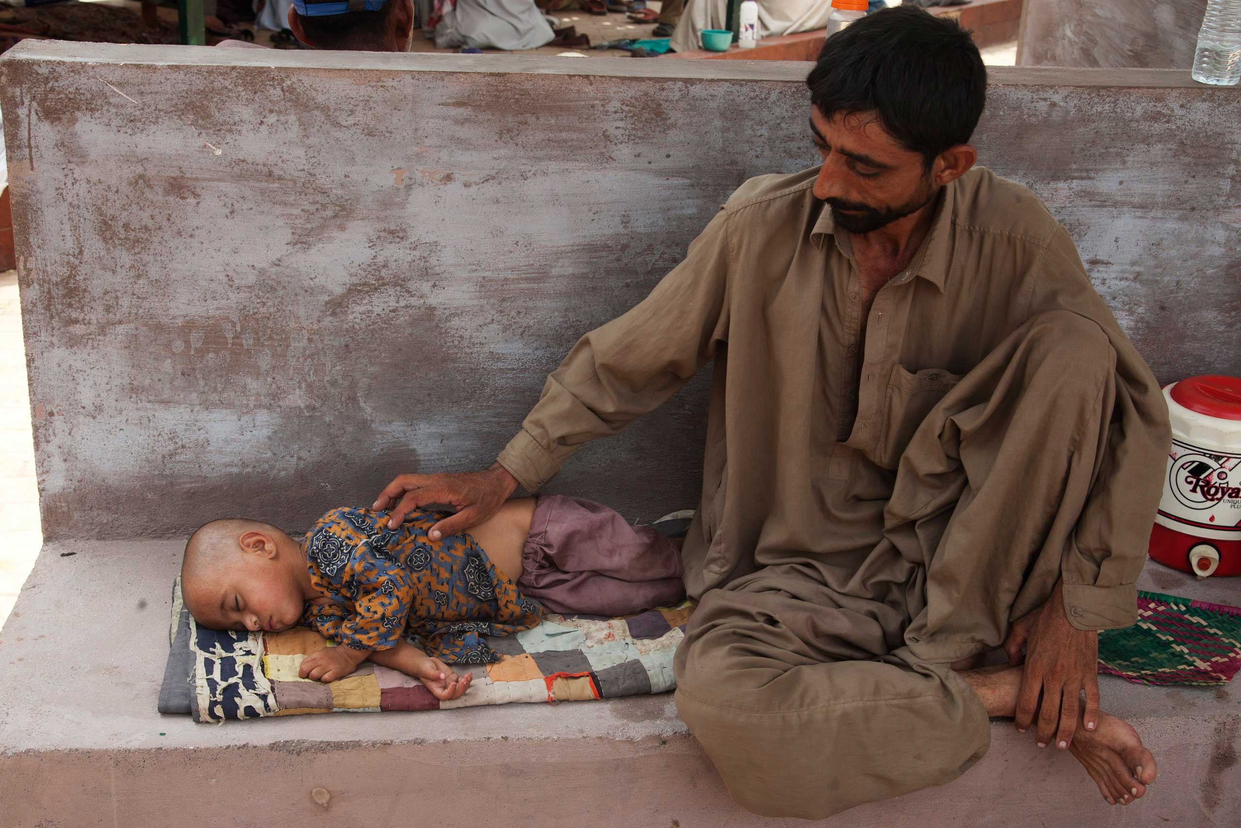 A man with his daughter who suffers from dehydration due to extreme weather waits for a medical help outside a ward at a child hospital in Karachi, Pakistan, on June 24, 2015. (Shakil Adil—AP)