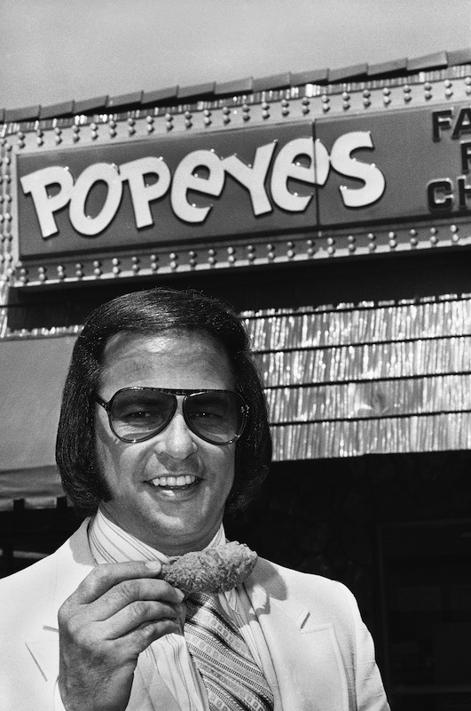 Al Copeland holds a piece of his spicy fried chicken outside one of his 34 fast food outlets in New Orleans, on June 20, 1979. (AP Images)