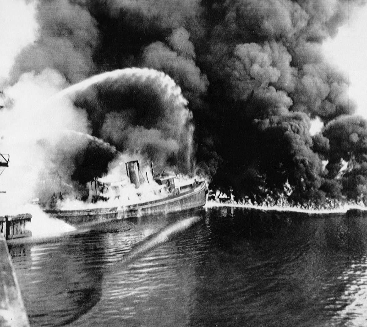 A fire tug fights flames on the Cuyahoga River near downtown Cleveland on June 25, 1952. (AP Images)