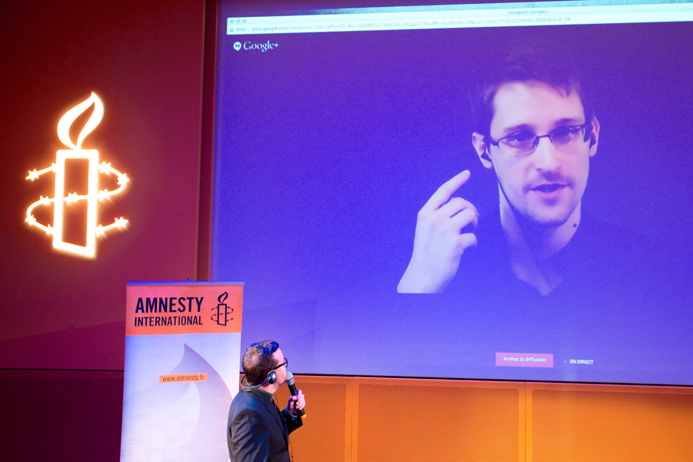 Former US National Security Agency contractor Edward Snowden, who is in Moscow, is seen on a giant screen during a live video conference for an interview as part of Amnesty International's annual Write for Rights campaign at the Gaite Lyrique in Paris