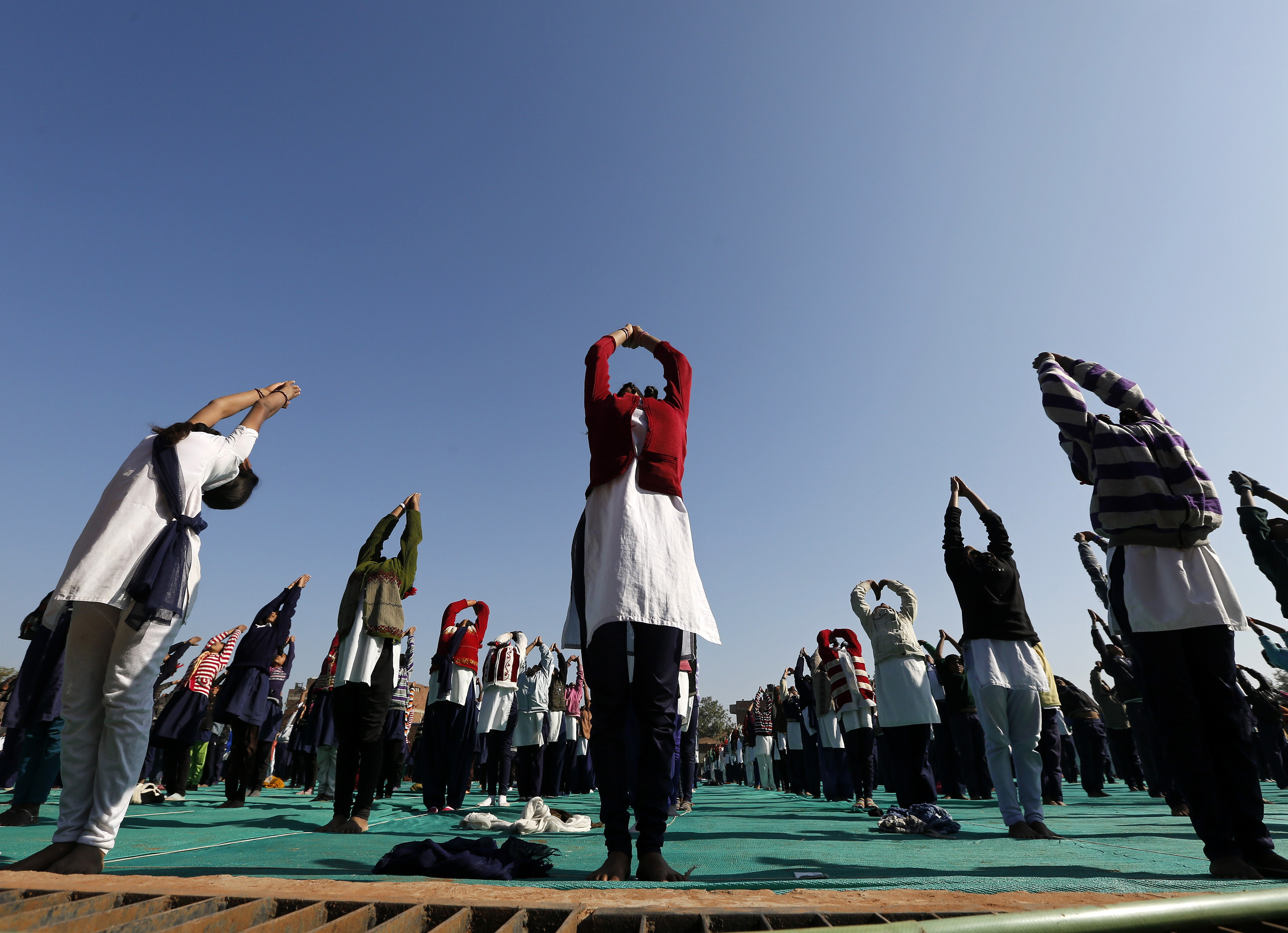 Schoolchildren offer prayers to Sun god during a yoga session at a camp in Ahmedabad