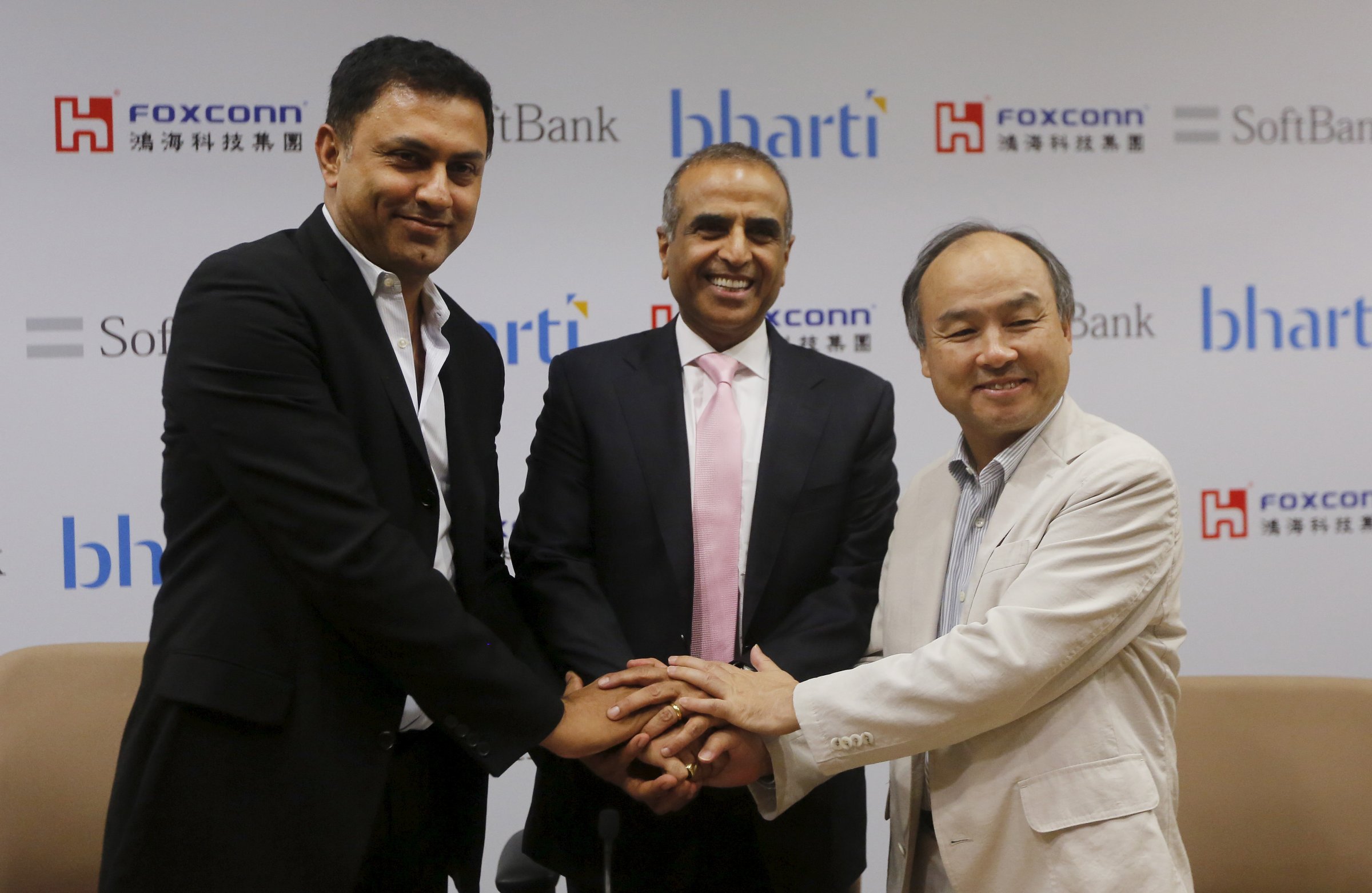 Son, founder and chief executive officer of Japan's SoftBank Corp., Arora, president of SoftBank Corp. and Mittal, chairman of Bharti Enterprises, shake hands before the start of a news conference in New Delhi