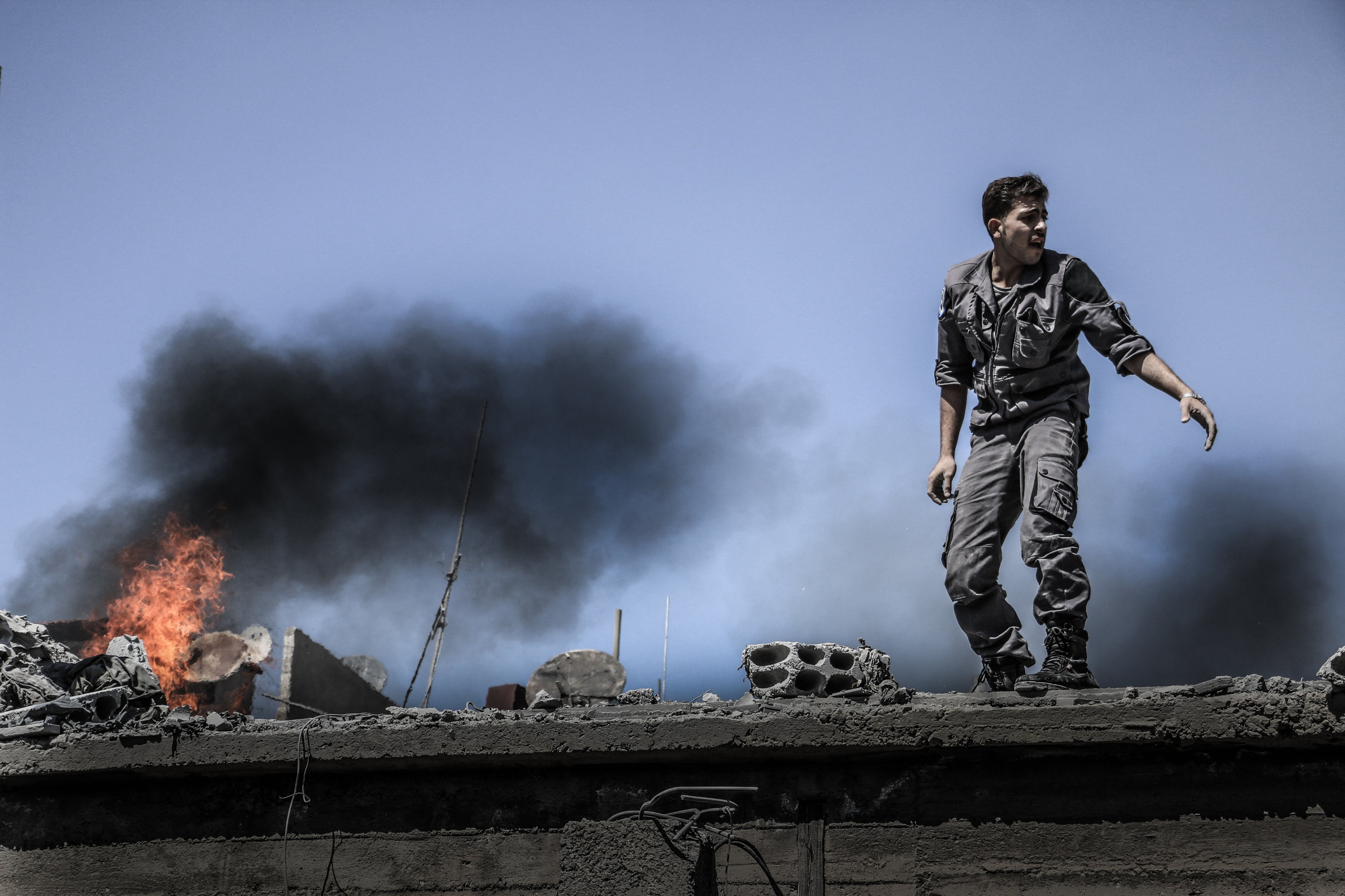 Civil defenses extinguish fires in a building destroyed in Arbin, Syria, on June 23, 2015. (Amer Almohipany—NurPhoto/AP)
