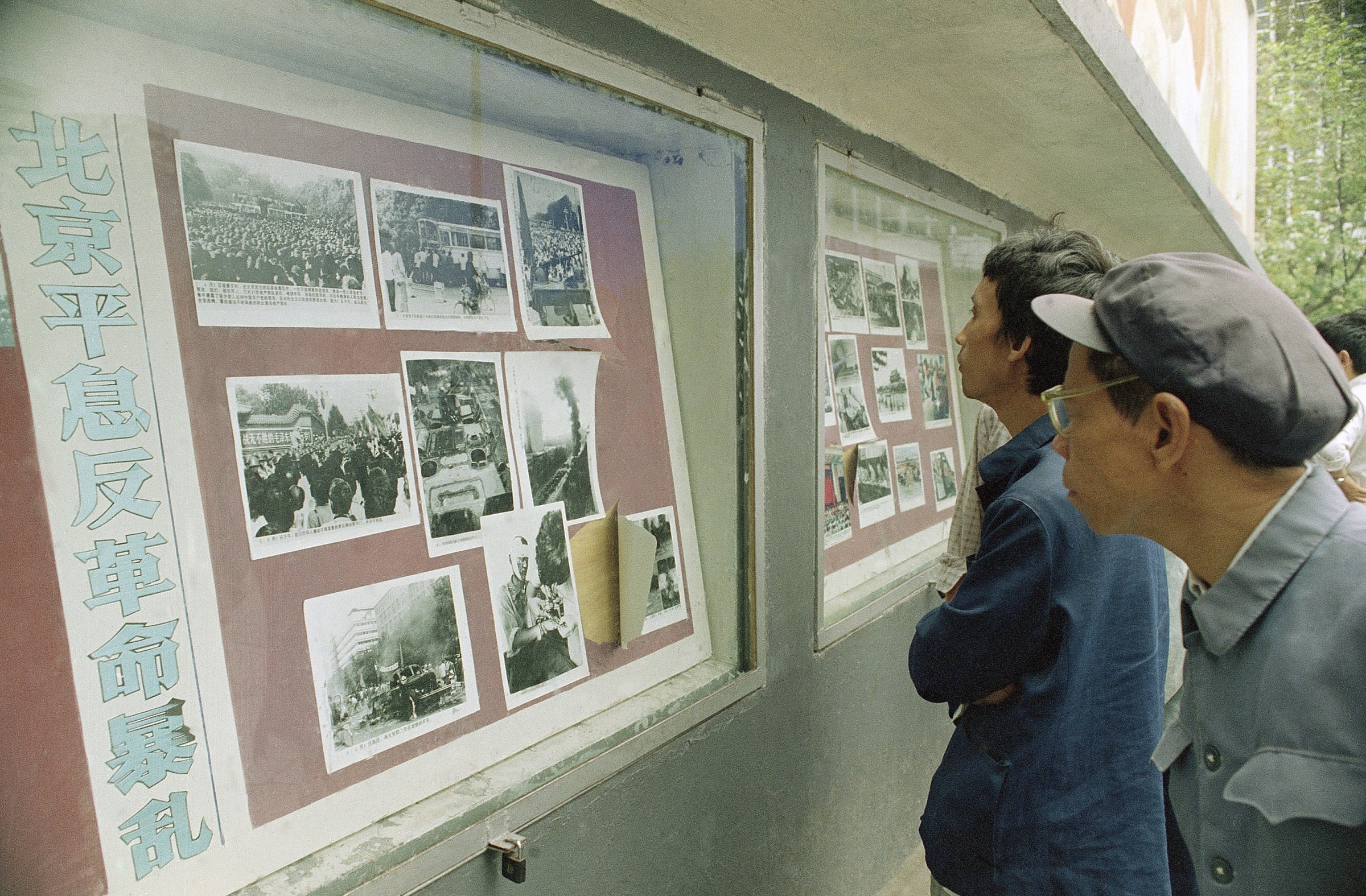 Viewers crowd around an official photo display in Chengdu, Sichuan Province, China Oct. 30, 1989 that depicts violent battles there in June between police and a crowd angered by the Beijing Tiananmen Square killings.