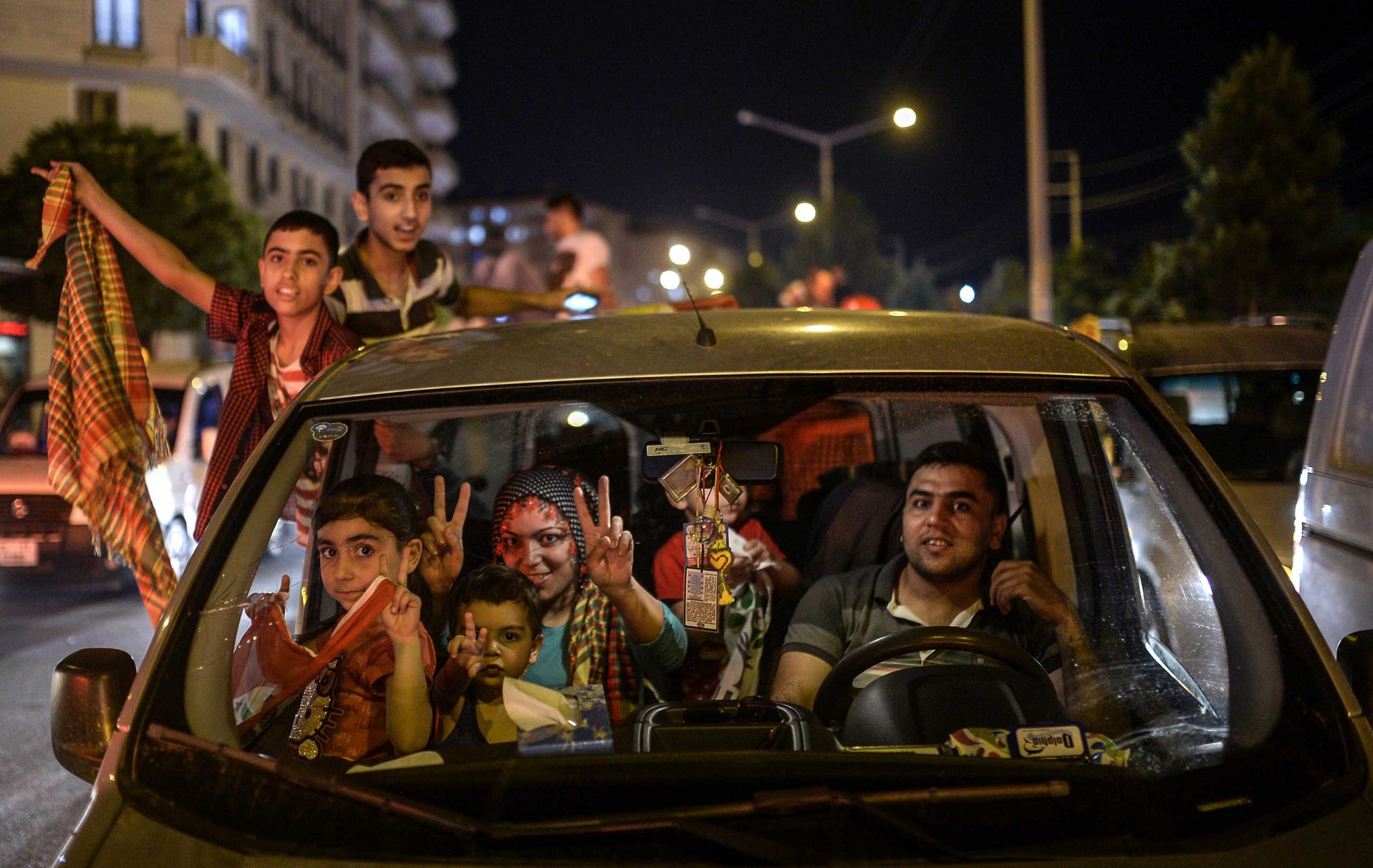 A family and children, supporters of pro-Kurdish Peoples' Democratic Party (HDP) celebrate the results of the legislative election, in Diyarbakir, Turkey, on June 7, 2015. (Bulent Kilic—AFP/Getty Images)