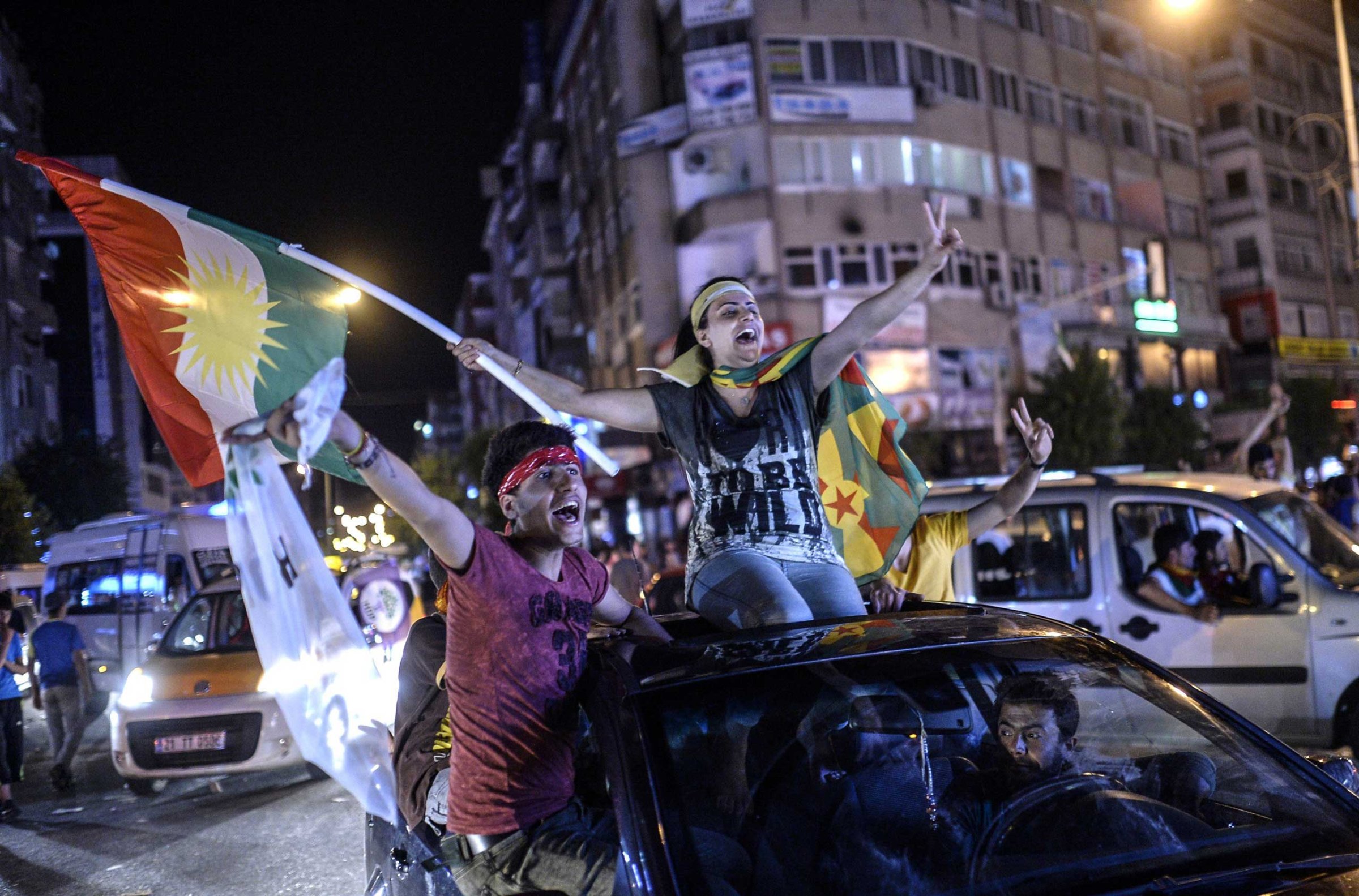 Young supporters of pro-Kurdish Peoples' Democratic Party (HDP) hold Kurdish flags as they celebrate the results of the legislative election, in Diyarbakir in Turkey on June 7, 2015.