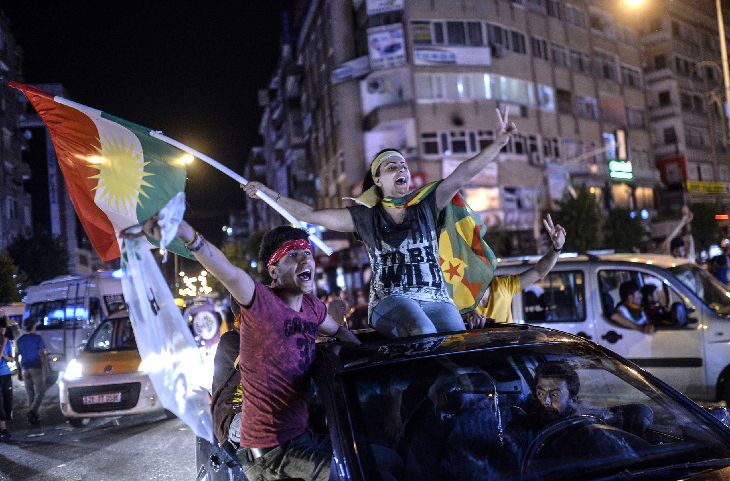Young supporters of pro-Kurdish Peoples' Democratic Party (HDP) hold Kurdish flags as they celebrate the results of the legislative election, in Diyarbakir in Turkey on June 7, 2015. (Bulent Kilic—AFP/Getty Images)