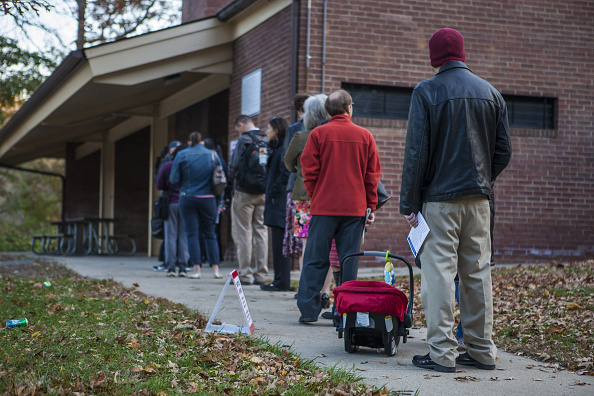Voters line up outside a polling station to cast their ballots within US mid-term elections in Rockville, Maryland, United States on November 4, 2014.