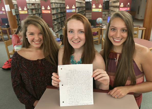 Apponequet Regional High School students, Mollykate Rodenbush, Brittany Tainsh, and Michaela Arguin (from left), hold the handwritten reply from Whitey Bulger.