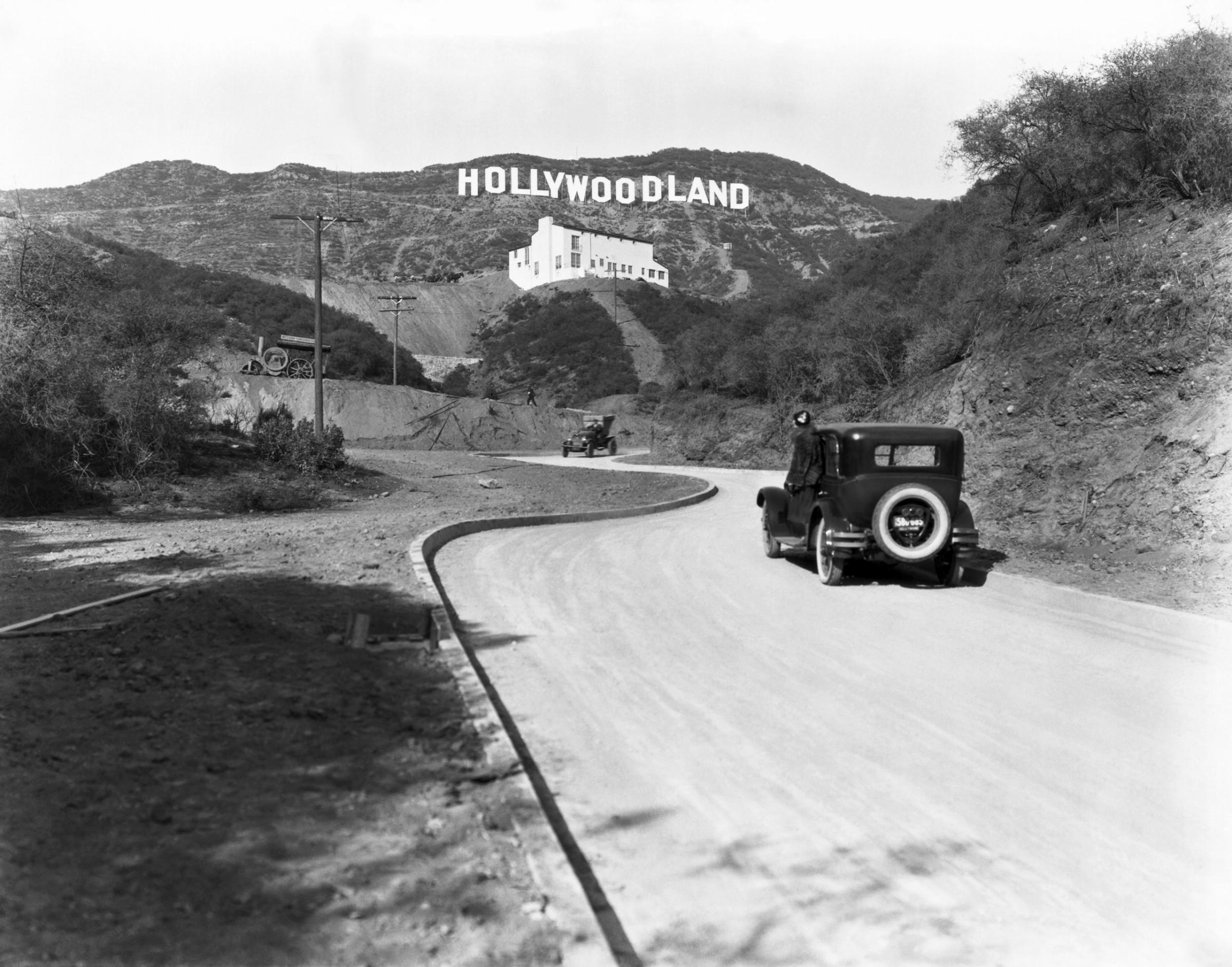 A sign advertises the opening of the Hollywoodland housing development in the hills on Mulholland Drive overlooking Los Angeles, Hollywood, circa 1924.