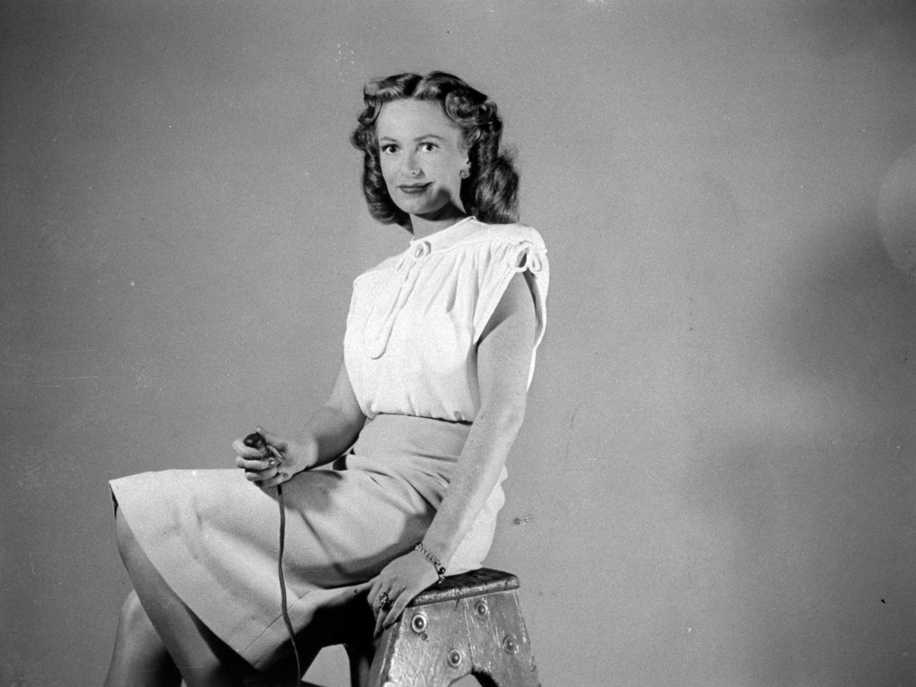 Actress Geraldine Fitzgerald holding shutter release as she takes her own photograph.