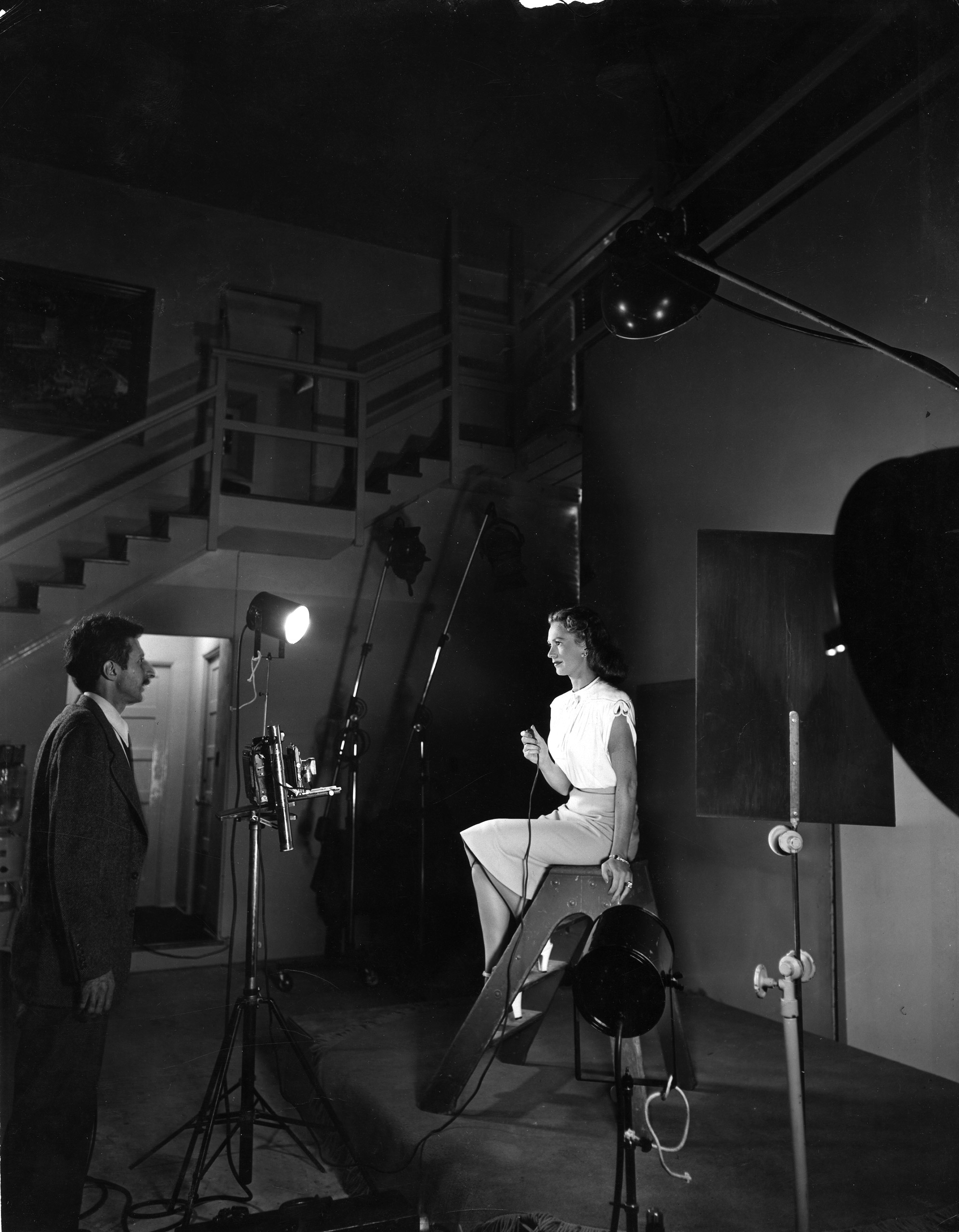 Photographer Gjon Mili instructing actress Geraldine Fitzgerald on how to take her own photograph.
