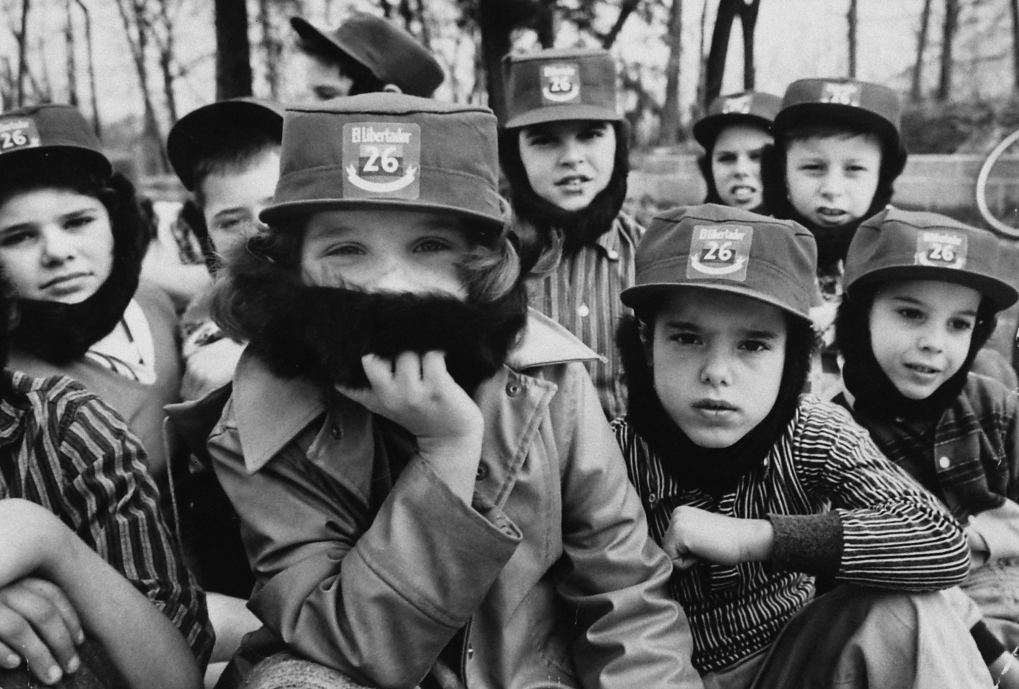 Children wearing Fidel Castro beards and hats, playing in the woods in 1959.