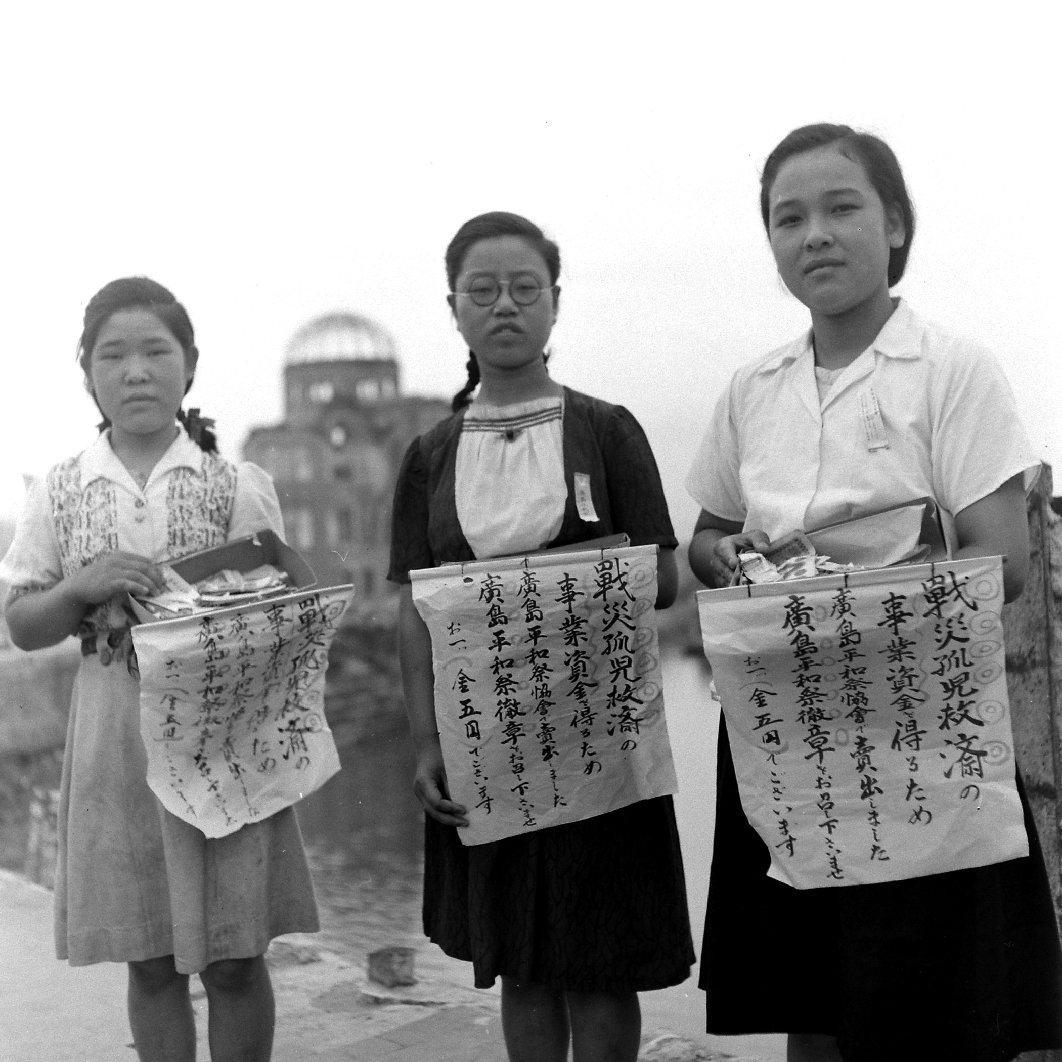 Girls selling peace ribbons during anniversary of bomb dropping in Hiroshima.