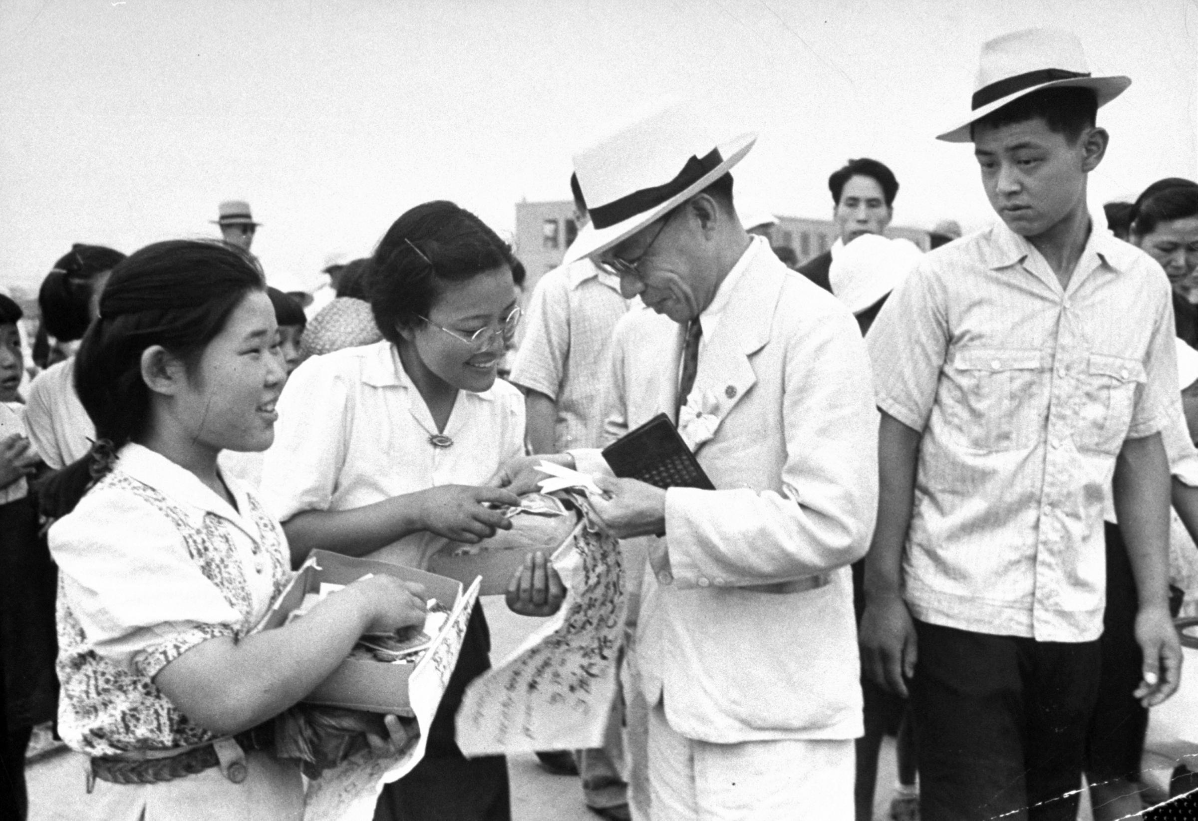 Girls selling peace ribbons during anniversary of bomb dropping in Hiroshima.
