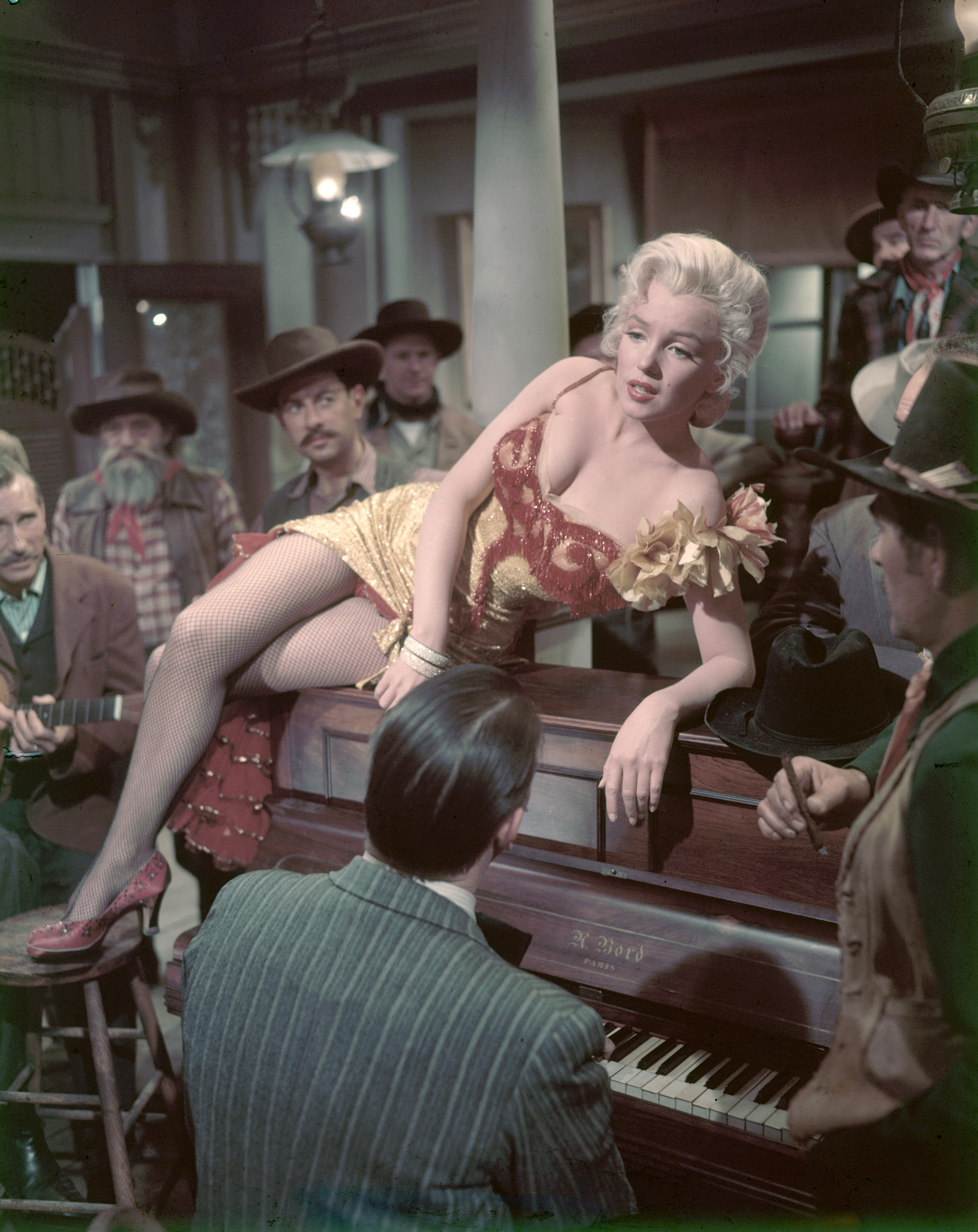 Marilyn Monroe sitting on a piano in a scene from movie "River of No Return," 1954.