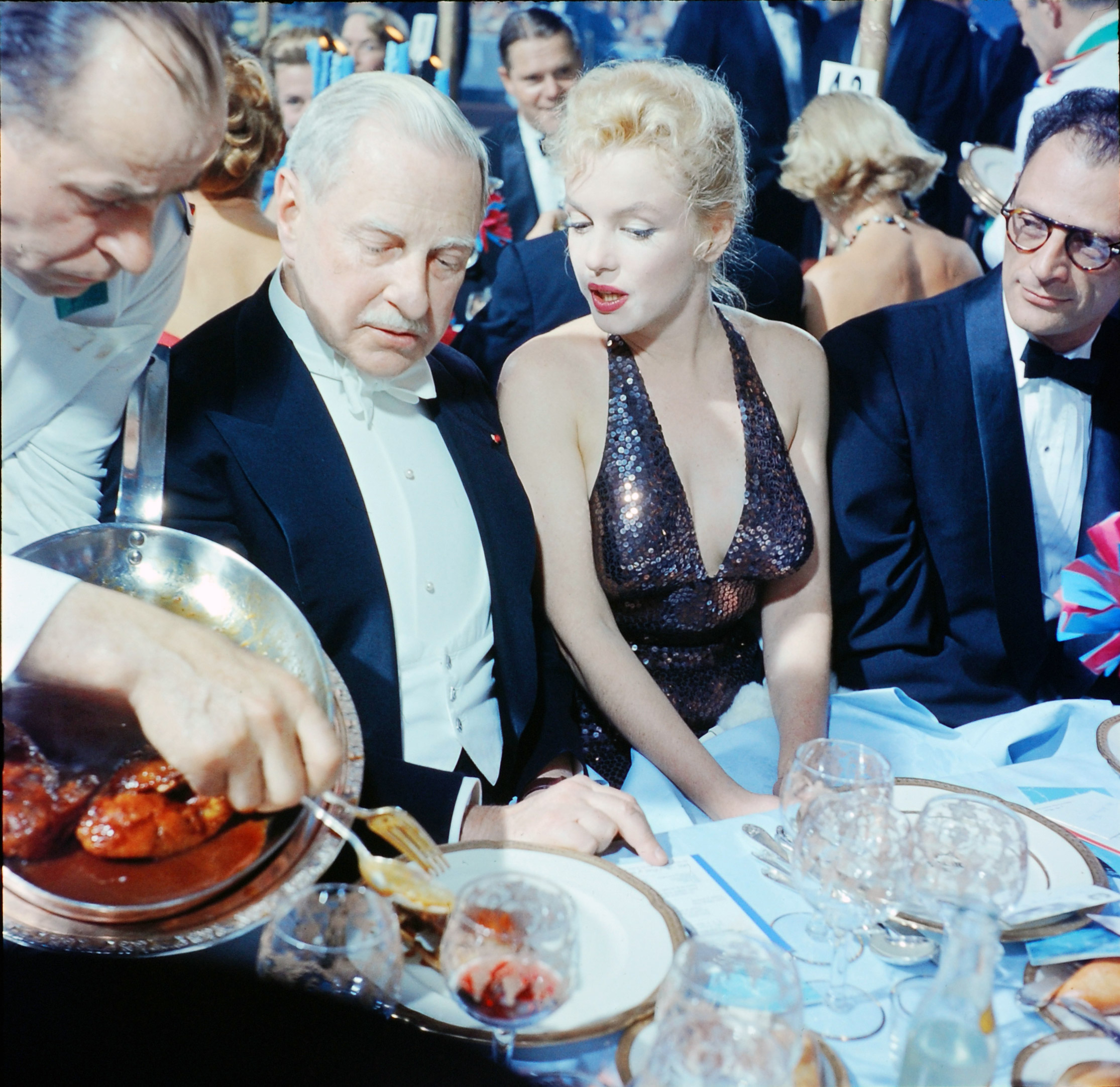 April in Paris Ball - Waldorf Astoria Hotel - Society Serves Charity and French-American relations in New York hosted by Mrs. William C.T. Gaynor. (L-R) Ambassador Winthrop Aldrich, ex-envoy to Britain chatting w. actress Marilyn Monroe as her husband, playwright Arthur Miller looks on, 1957.