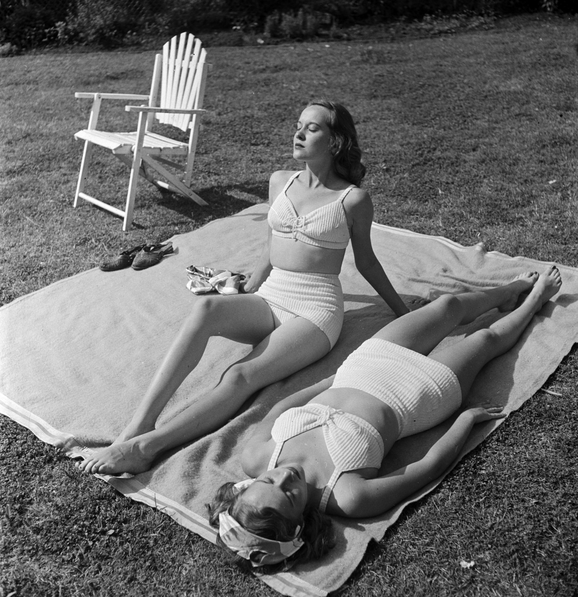 Identical twins, Barbara and Betty Bounds sunbathing.