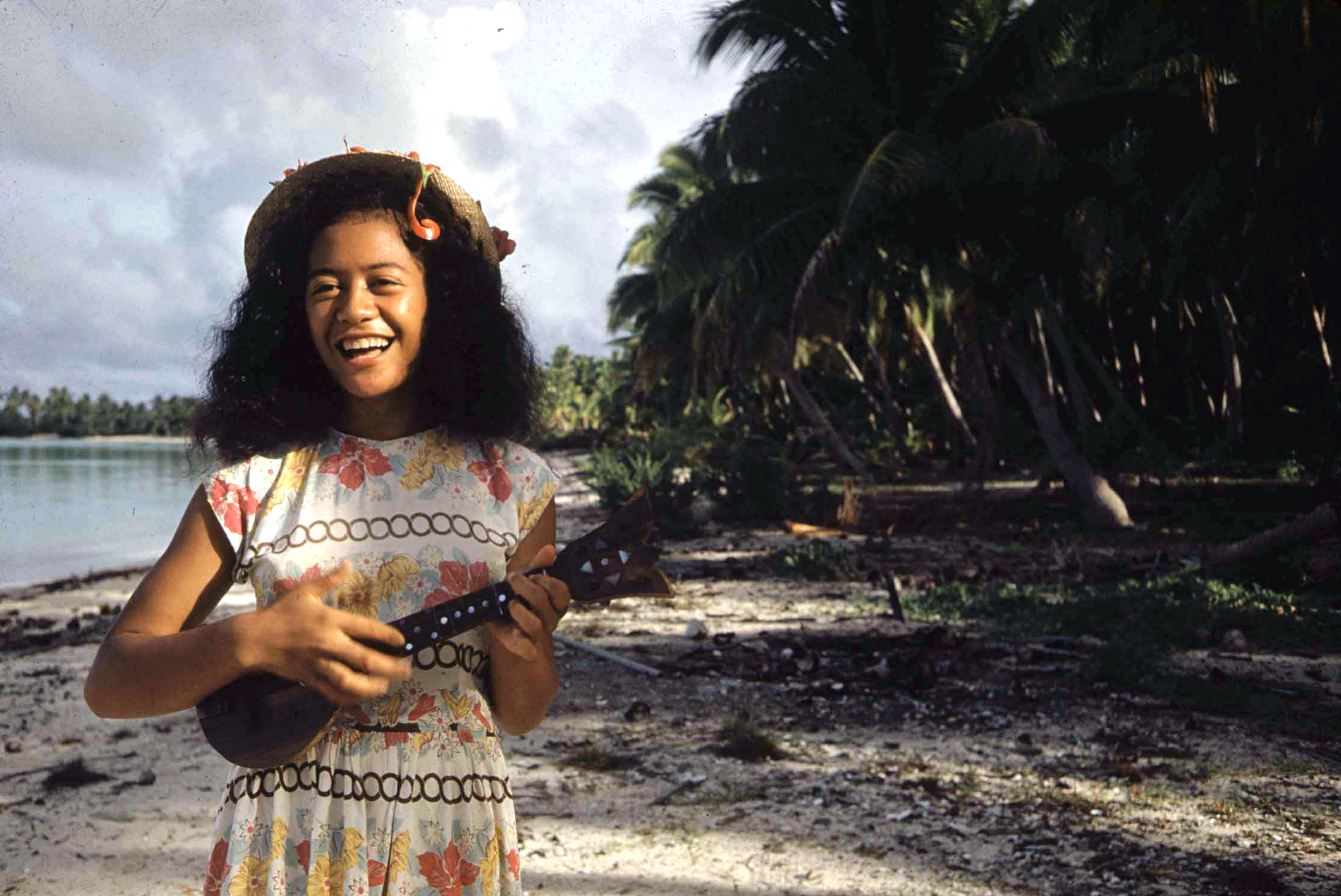 A Tahitian woman playing the Ukelele.