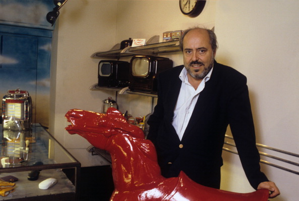 The Italian stylist Elio Fiorucci poses resting his left hand on a sculpted red horse in 1994 (Adriano Alecchi—Mondadori via Getty Images)