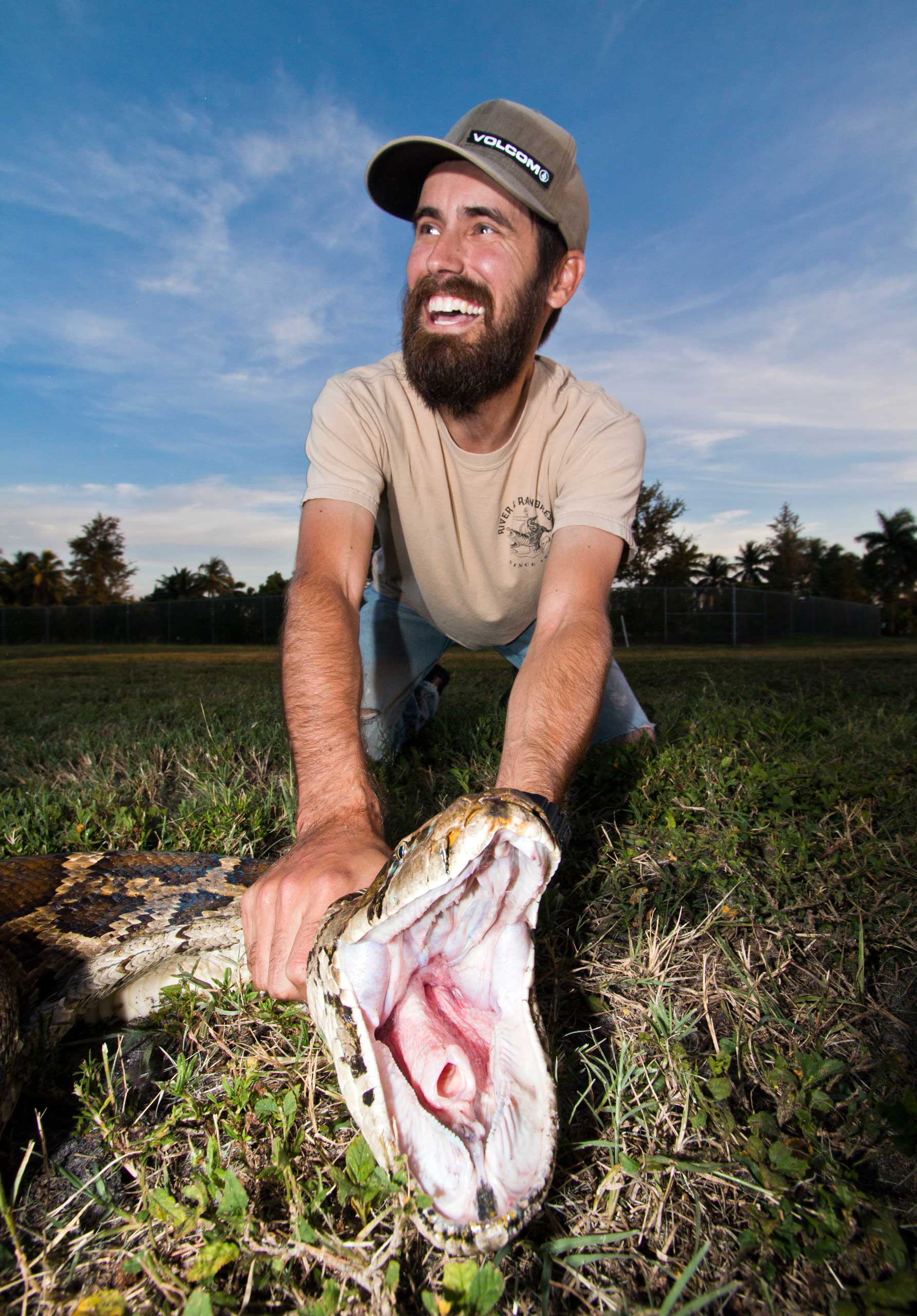 University of Florida wildlife biologist Ed Metzger with the female snake measuring 18 feet, 3 inches, and weighing 133 pounds.