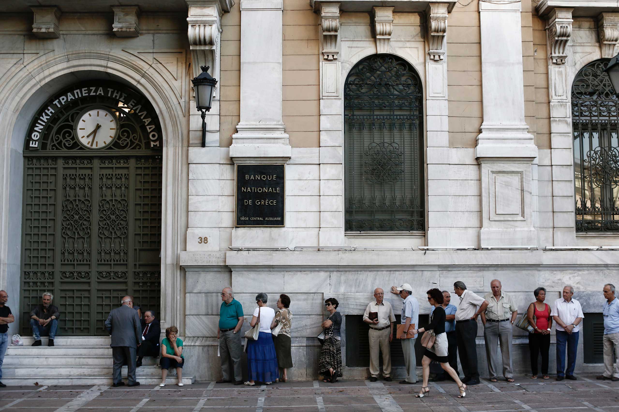 Customers queue outside a National Bank of Greece SA bank branch ahead of opening in Athens, July 20, 2015. (Bloomberg/Getty Images)