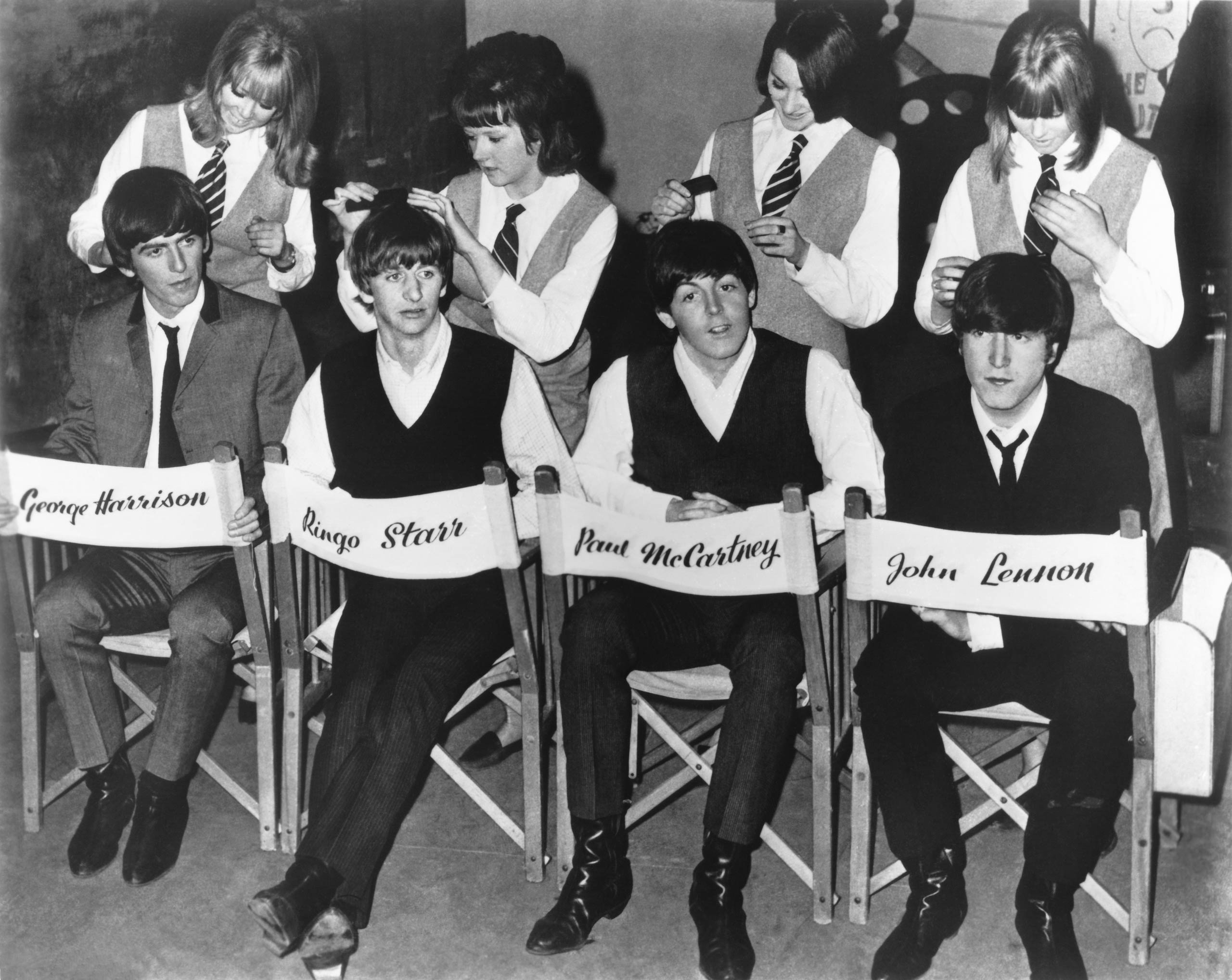 The Beatles are attended to by hairdressers during a break in the filming of A Hard Day's Night, 1964.