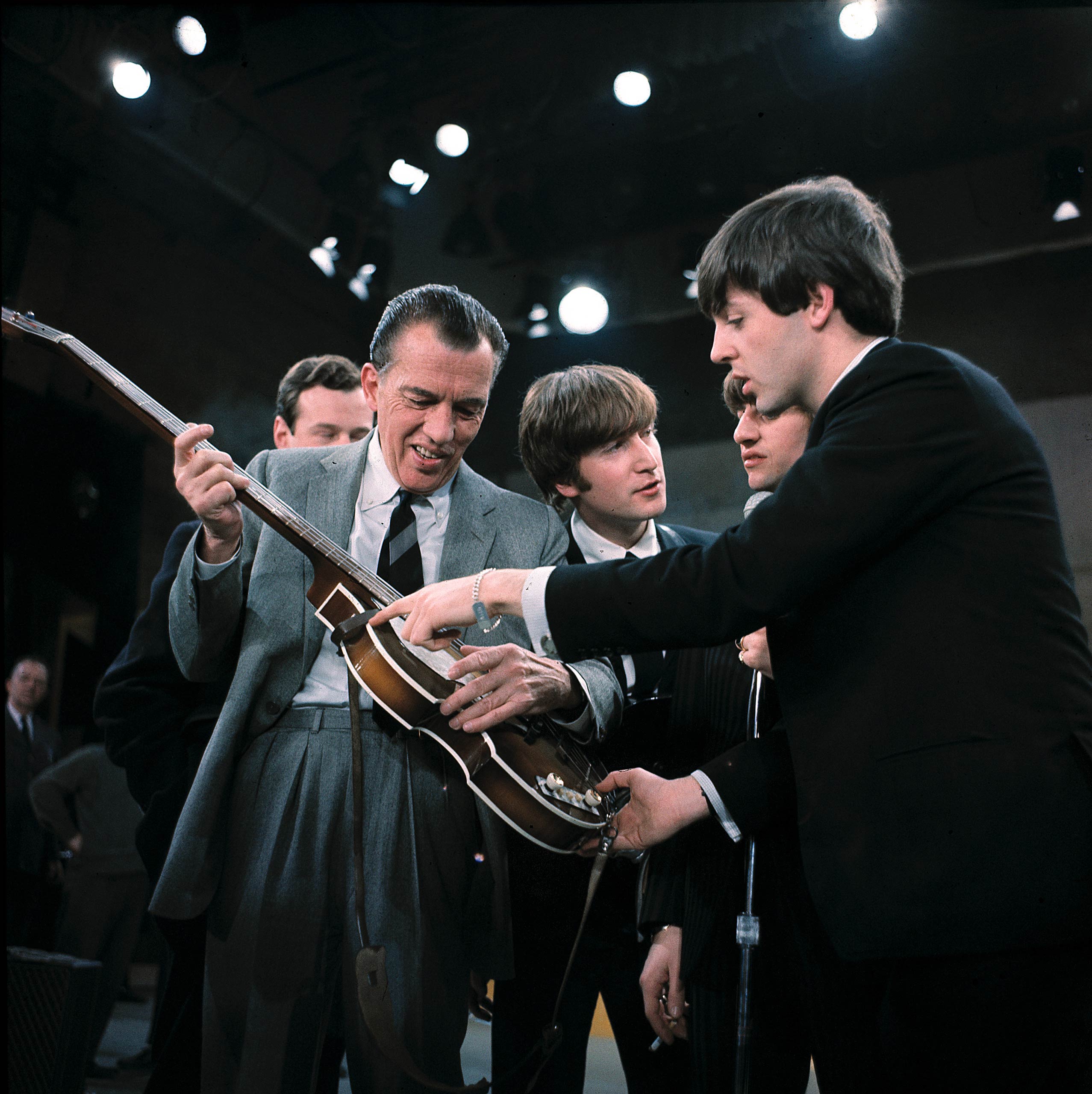 Paul McCartney, right, shows his guitar to Ed Sullivan before the Beatles' live television appearance on The Ed Sullivan Show in New York on Feb. 9, 1964.