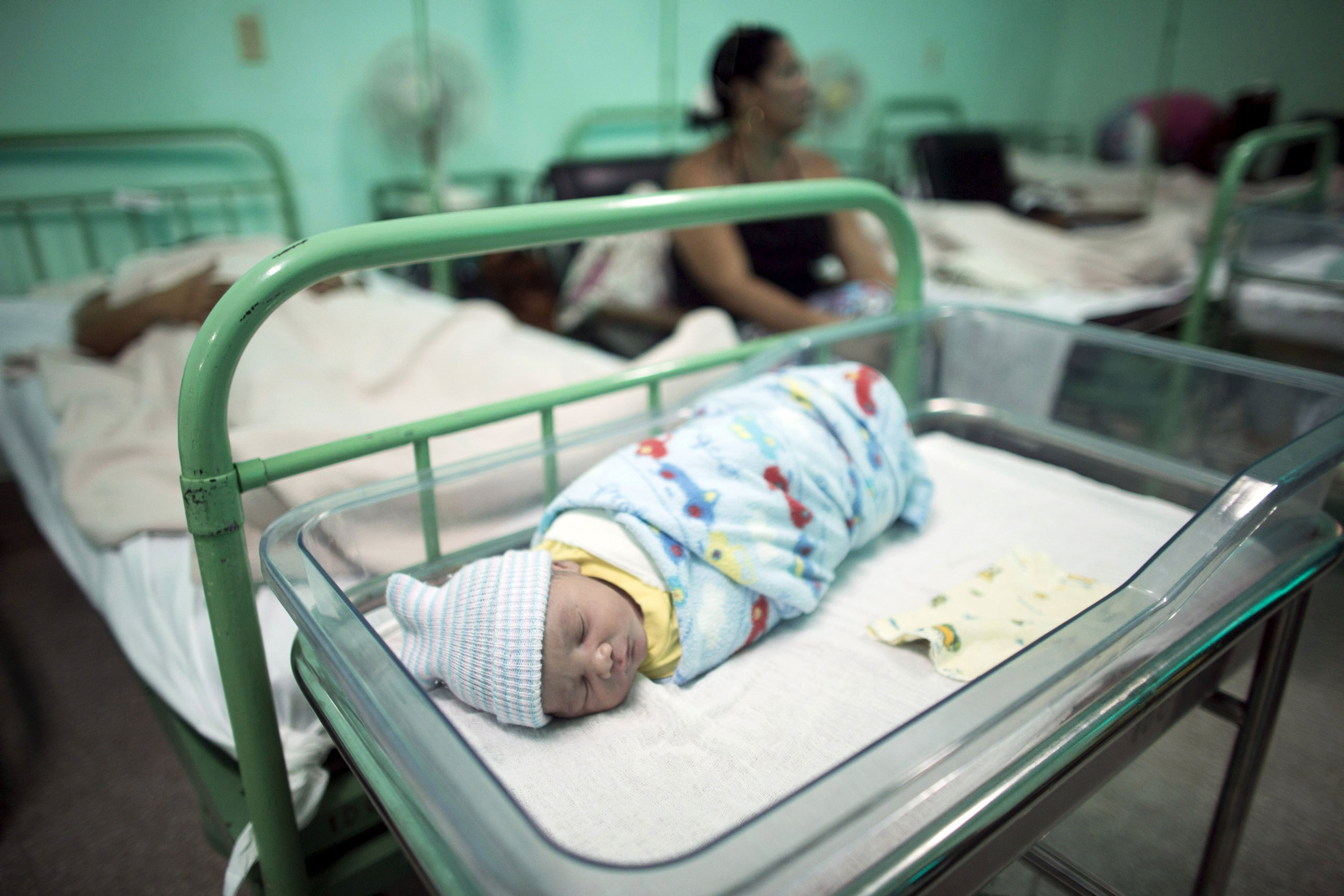 A new born baby rests beside his mother at the Ana Betancourt de Mora Hospital in Camaguey, Cuba, June 19, 2015. The World Health Organization on Tuesday declared Cuba the first country in the world to eliminate the transmission of HIV and syphilis from mother to child. Picture taken June 19, 2015. REUTERS/Alexandre Meneghini