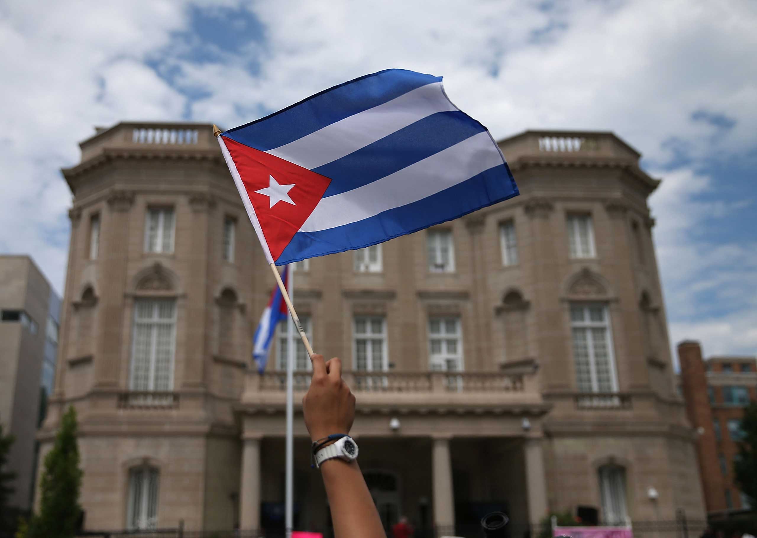 A supporter waves a Cuban flag in front of the country's embassy after it re-opened for the first time in 54 years in Washington, DC., July 20, 2015 (Mark Wilson — Getty Images)