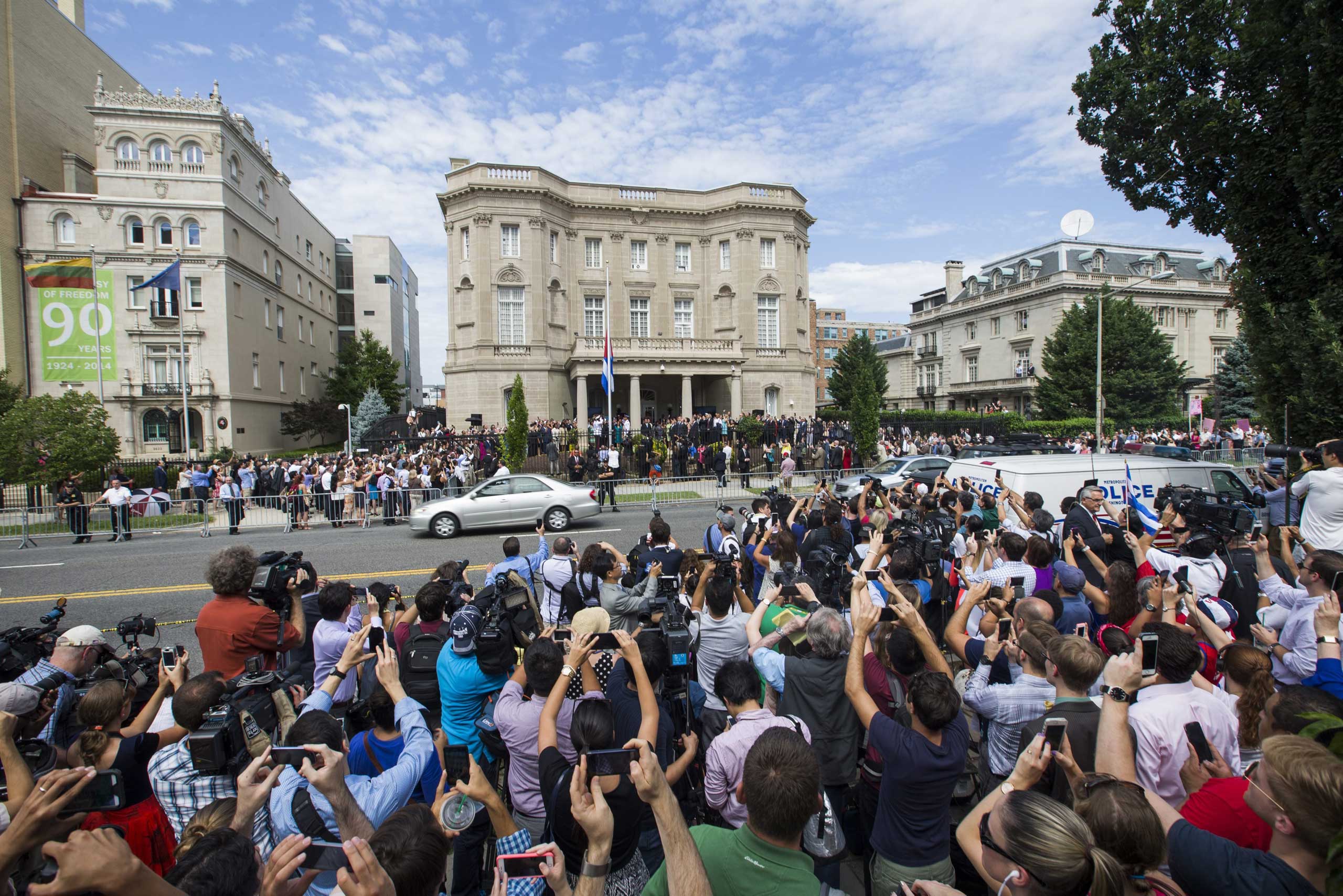 A large crowd of people gather to watch the Cuban flag being raised outside the Cuban embassy in Washington on July 20, 2015.
