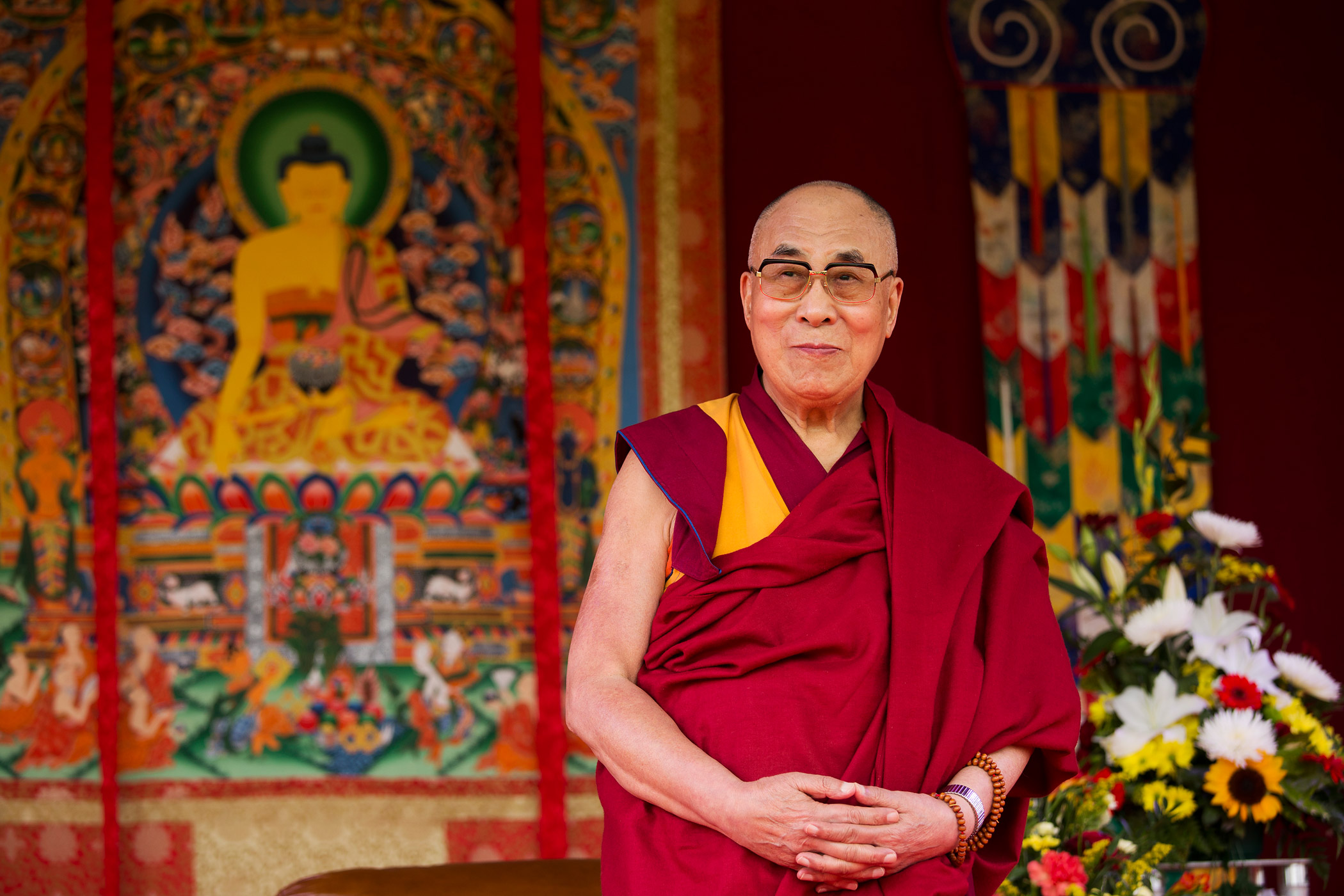 The Dalai Lama stands on stage before making a speech to an audience at the ESS Stadium in Aldershot, England, on June 29, 2015 (Matt Dunham—AP)