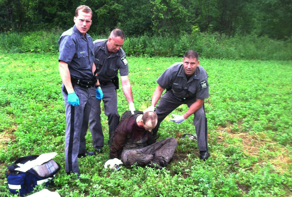 Police stand over David Sweat after he was shot and captured near the Canadian border June 28, 2015, in Constable, N.Y. (AP)