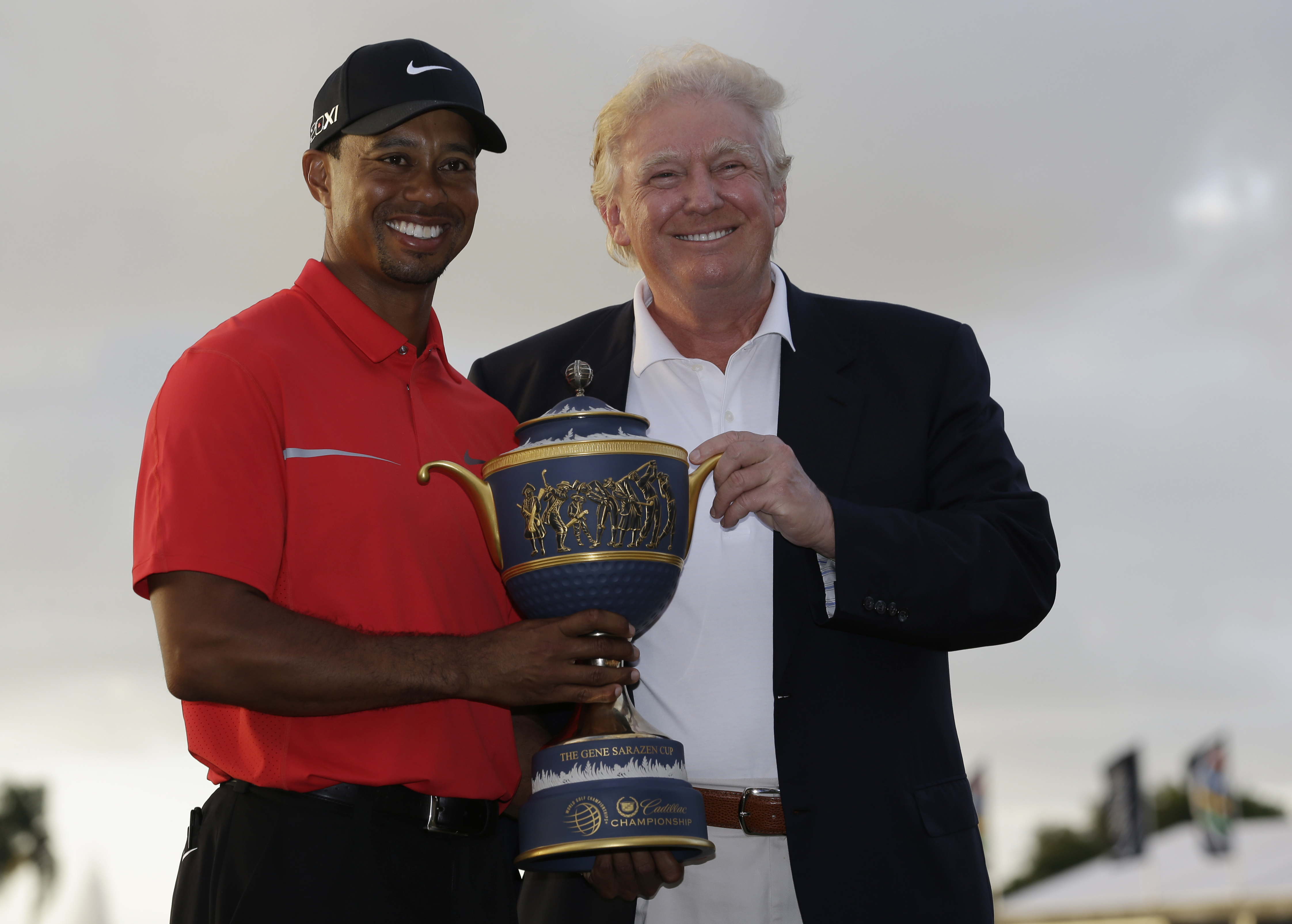 Tiger Woods stands with Donald Trump as he holds the Gene Serazen Cup for winning the Cadillac Championship golf tournament on March 10, 2013, in Doral, Fla.
